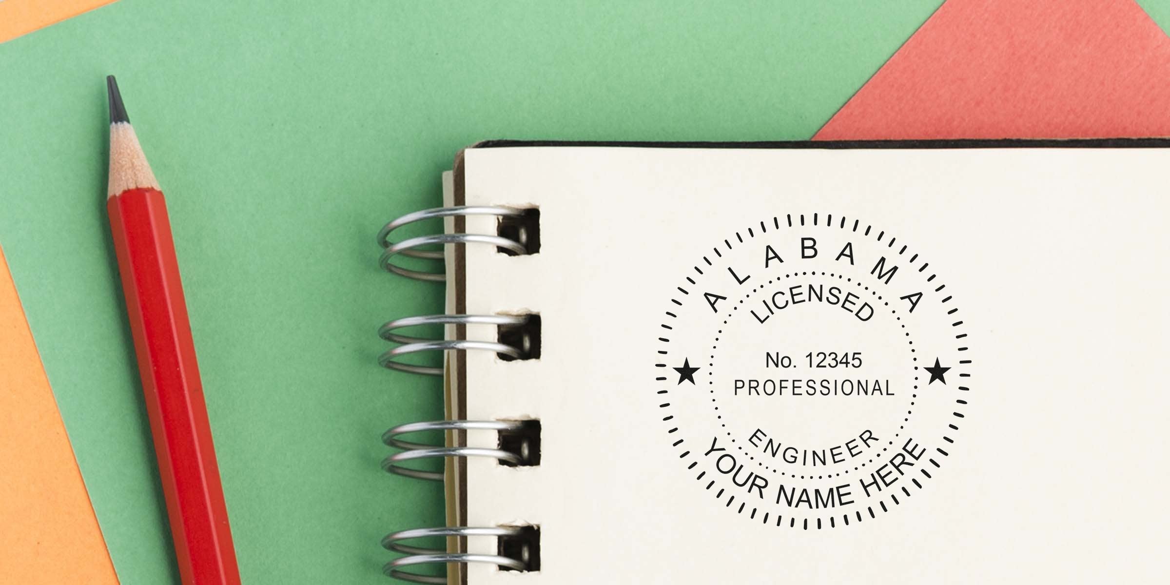 Red pencil next to Alabama engineer stamp embossed on spiral notebook for license verification and engineering certification using Alabama engineer embosser.