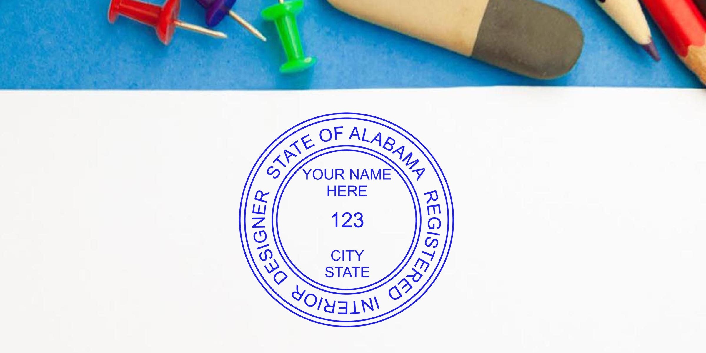 Blue Alabama interior designer stamp on white paper with colorful push pins and pencils on a blue background, symbolizing Alabama interior design application.