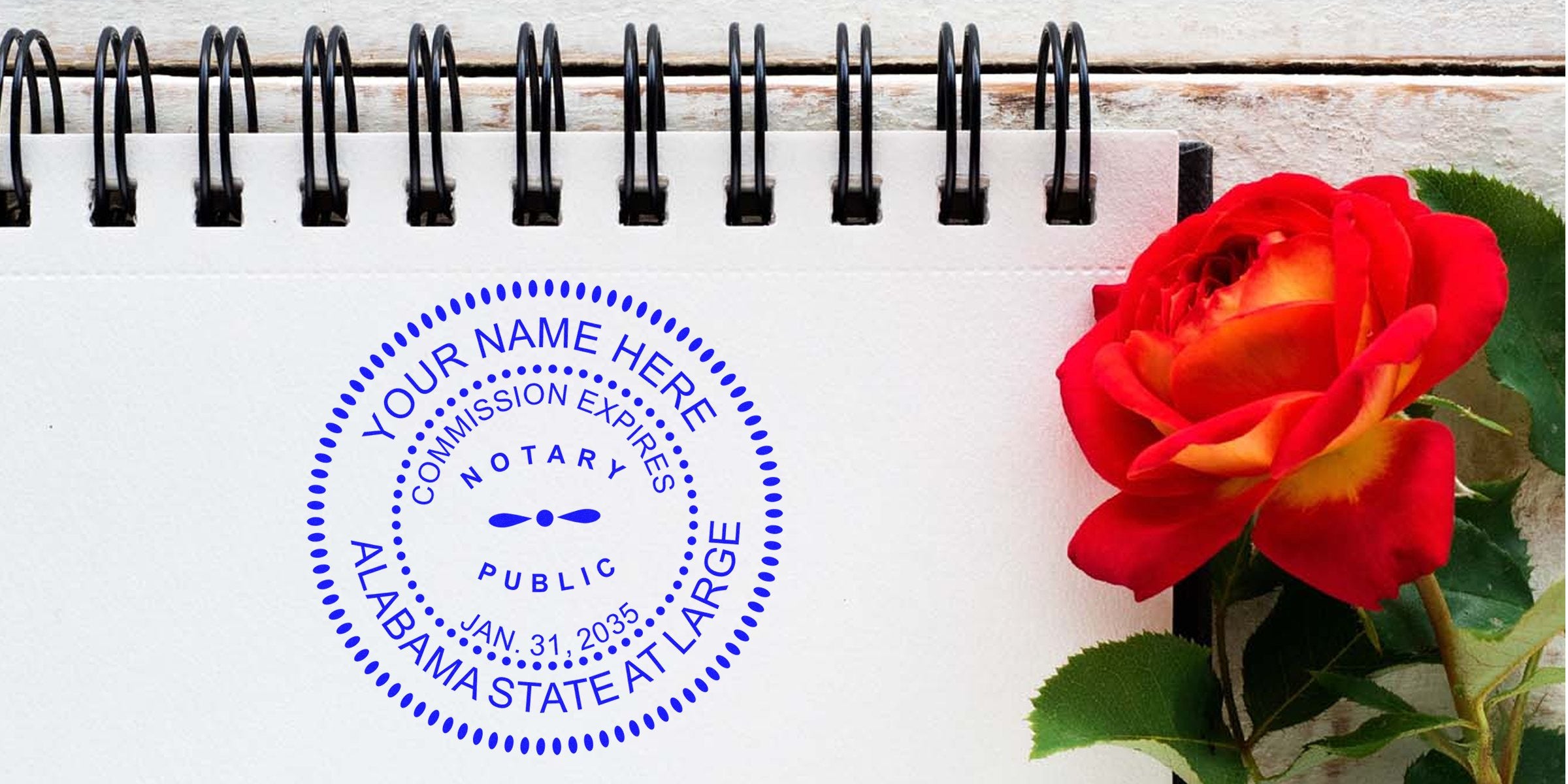 Alabama notary stamp on a spiral notebook with a red rose on a wooden table, representing trustworthy notary services.