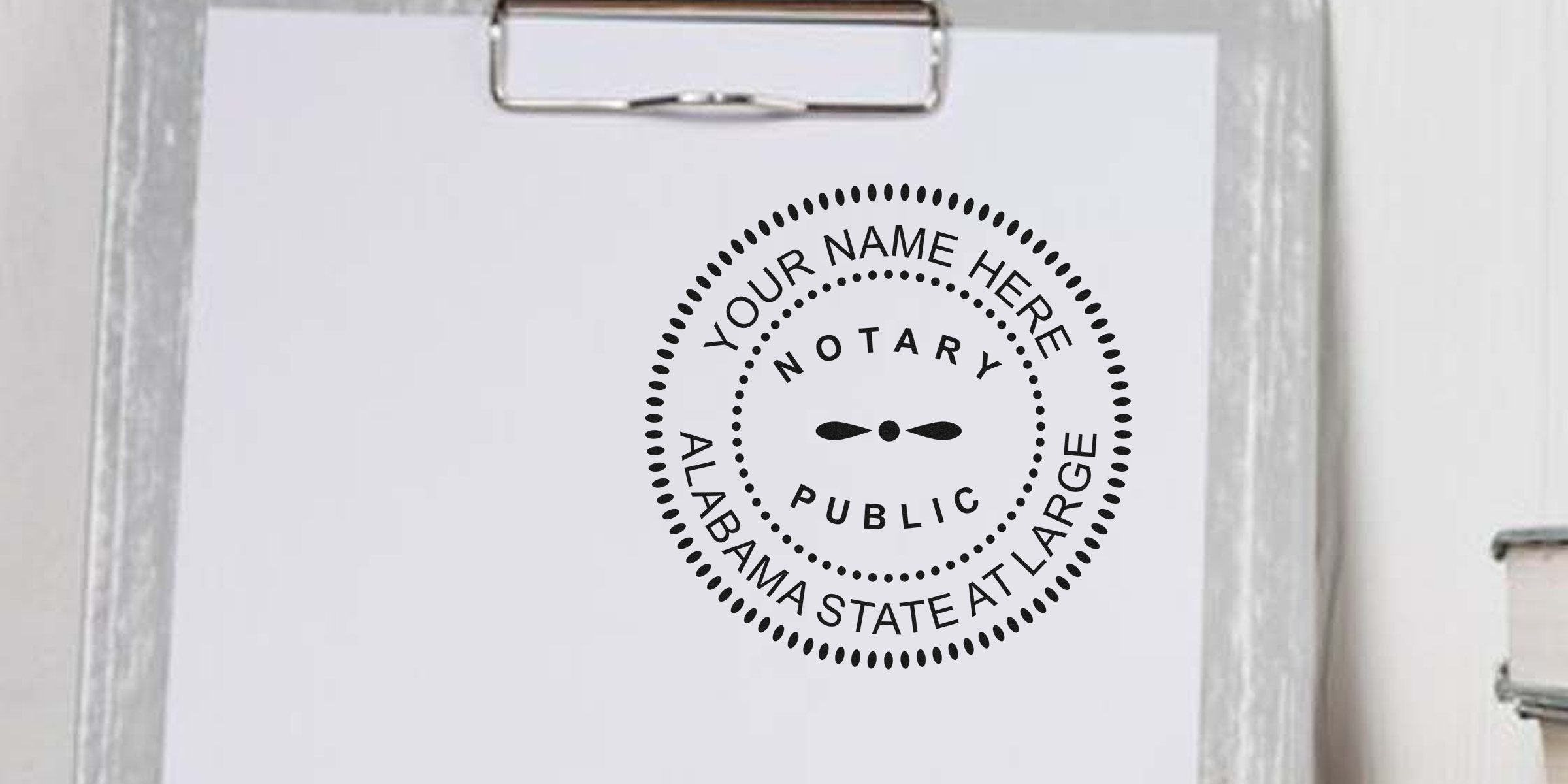 Alabama notary stamp on clipboard with blank paper for official use. Purchase your notary stamp online today.