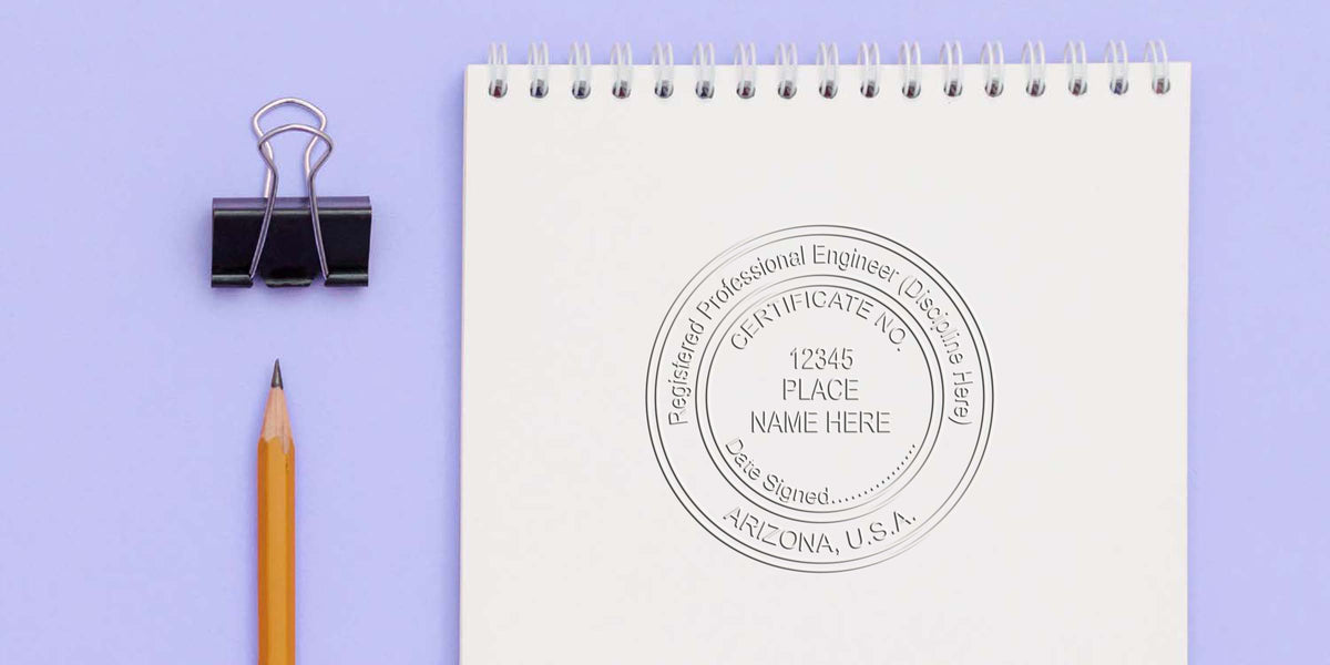 Arizona PE stamp embossed on white notepad with pencil and binder clip on purple background, showcasing engineering embossing tool.