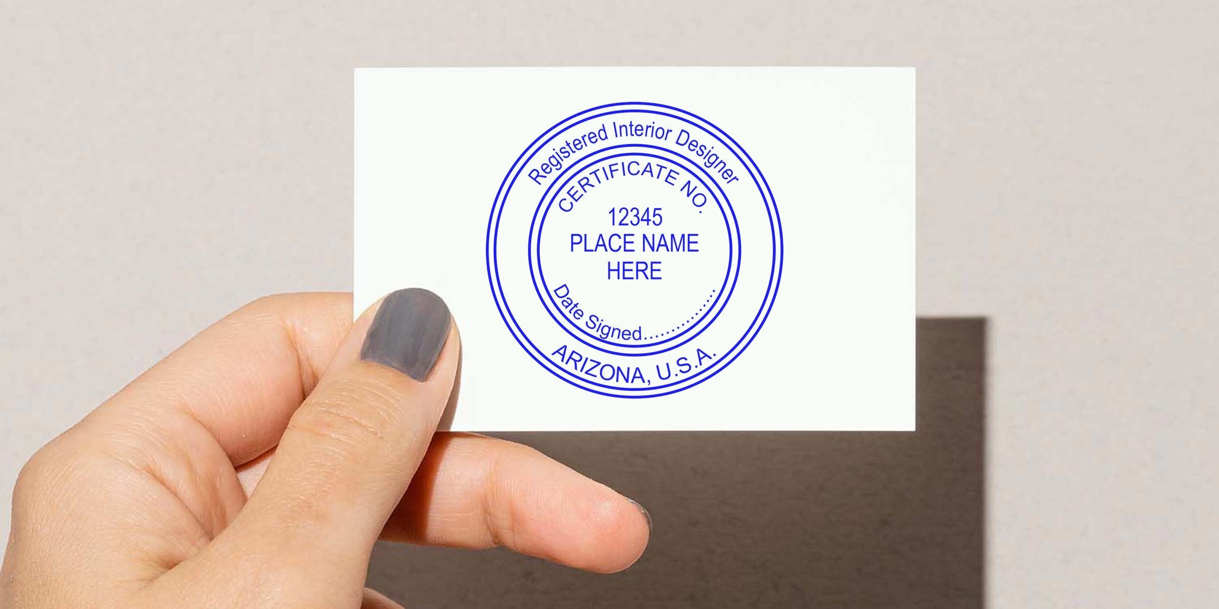 Hand holding a registered interior designer certificate stamp showing certificate number and Arizona location, highlighting Arizona interior design regulations and seal requirements.