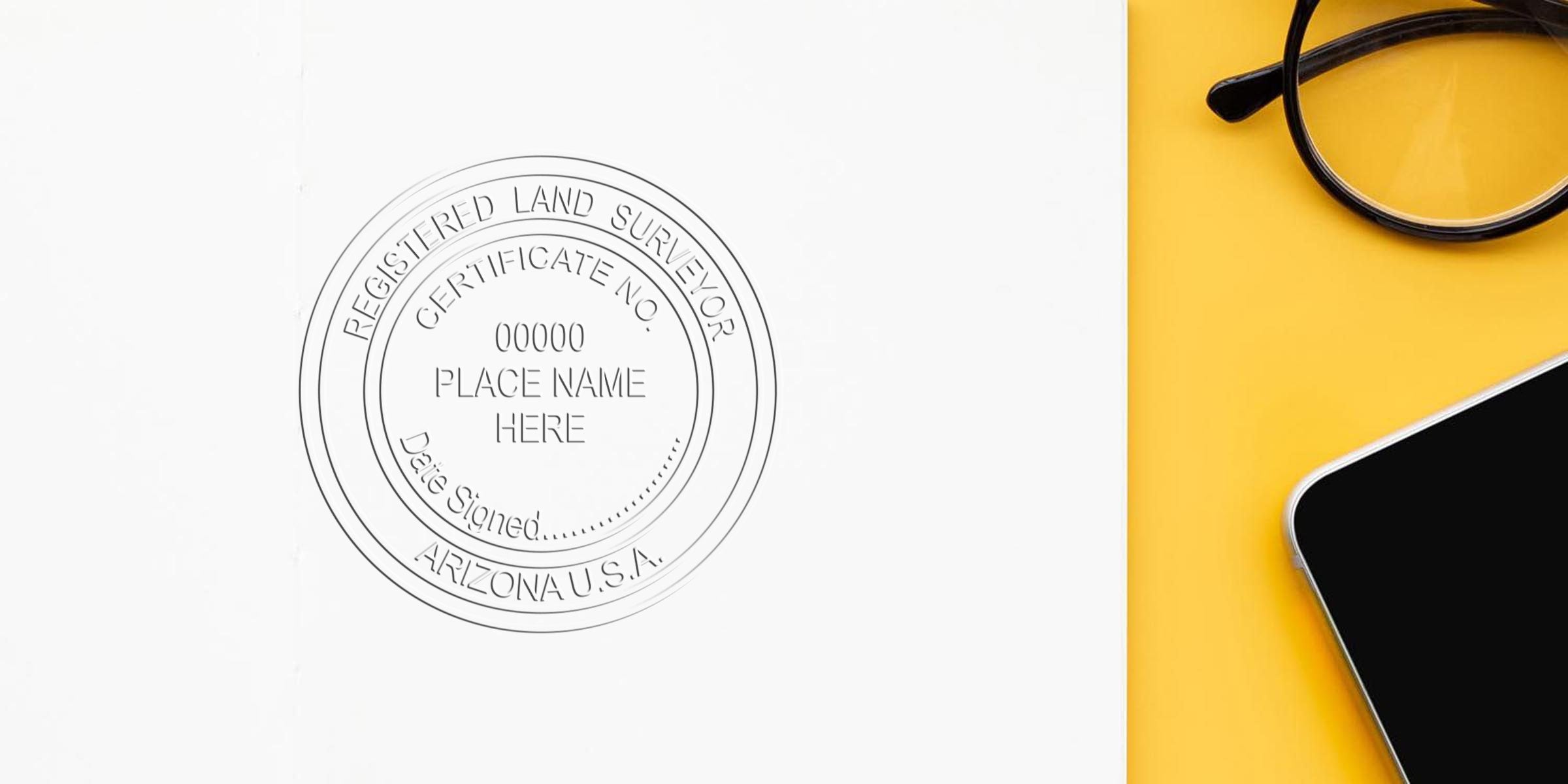 Arizona land surveyor stamp on white paper with smartphone and glasses on yellow background, symbolizing expert land surveying services in Arizona.