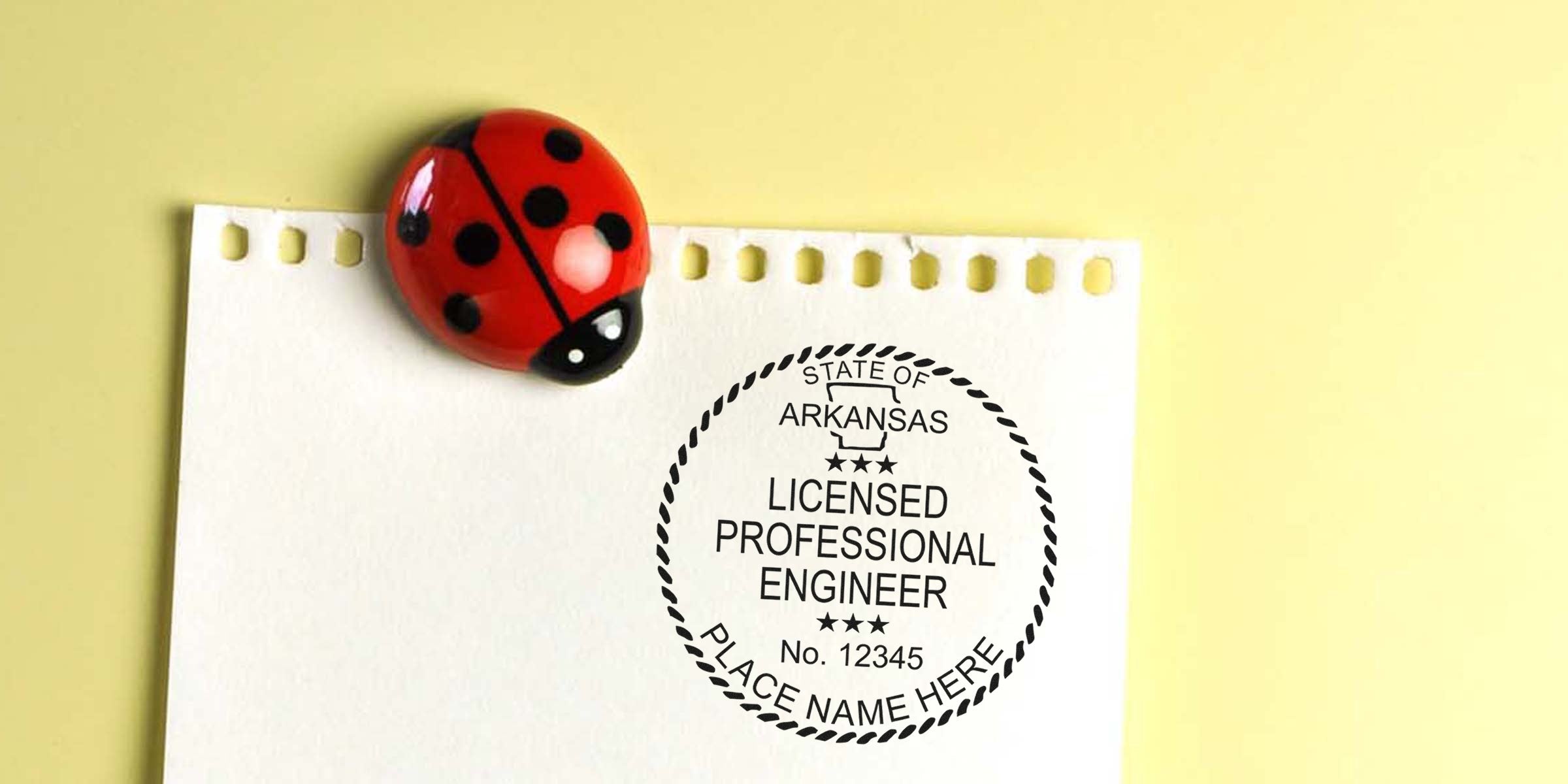 Arkansas PE stamps on paper with licensed engineer seal and ladybug magnet on yellow background. Buy PE stamps online.
