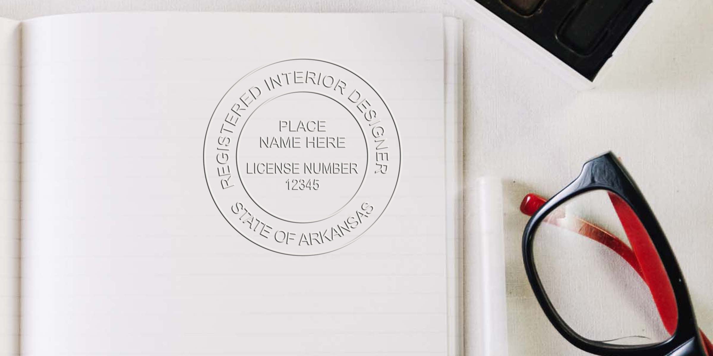 Arkansas interior designer seal on notebook with glasses and watercolor palette, highlighting Arkansas interior design license and professional certification.
