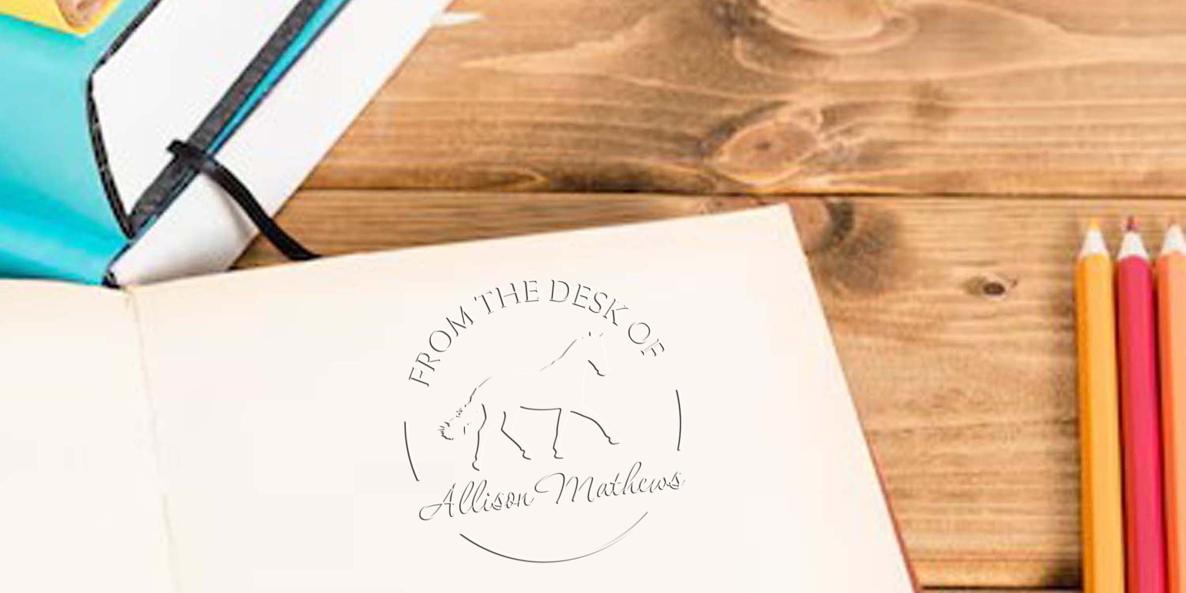 Open personalized notebook on a wooden desk with colored pencils, a sketchbook, and horse-themed “From the Desk of Allison Mathews” branding.