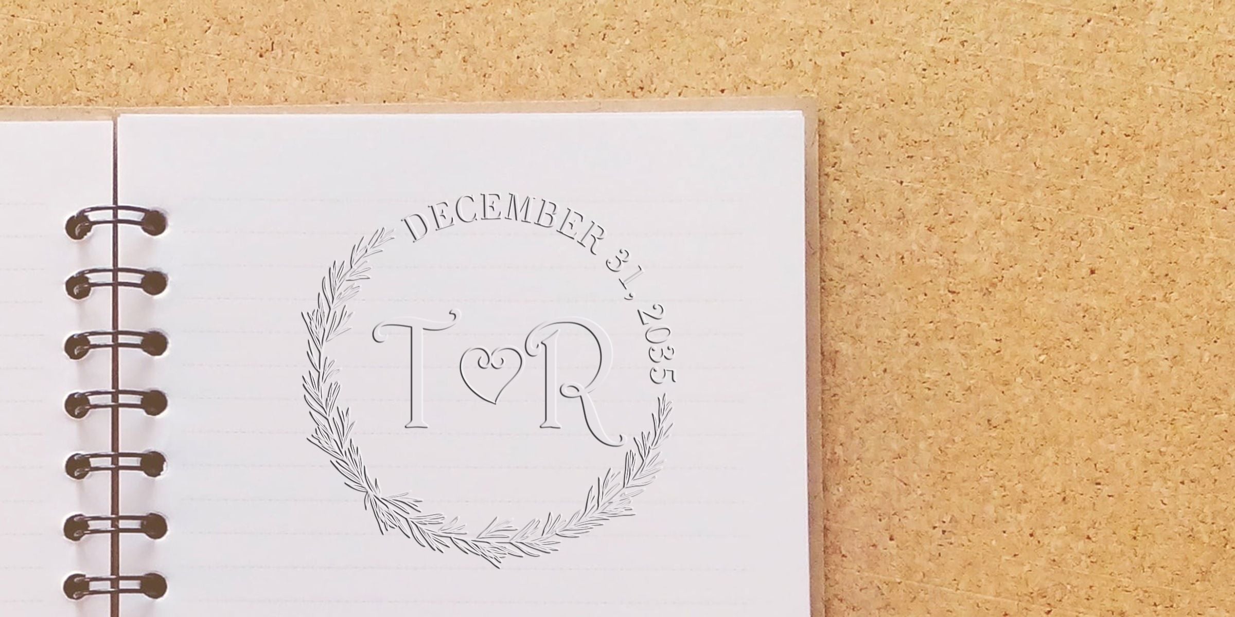 Personalized monogram TR planner notebook page with laurel wreath and December 31, 2025 date on a cork background