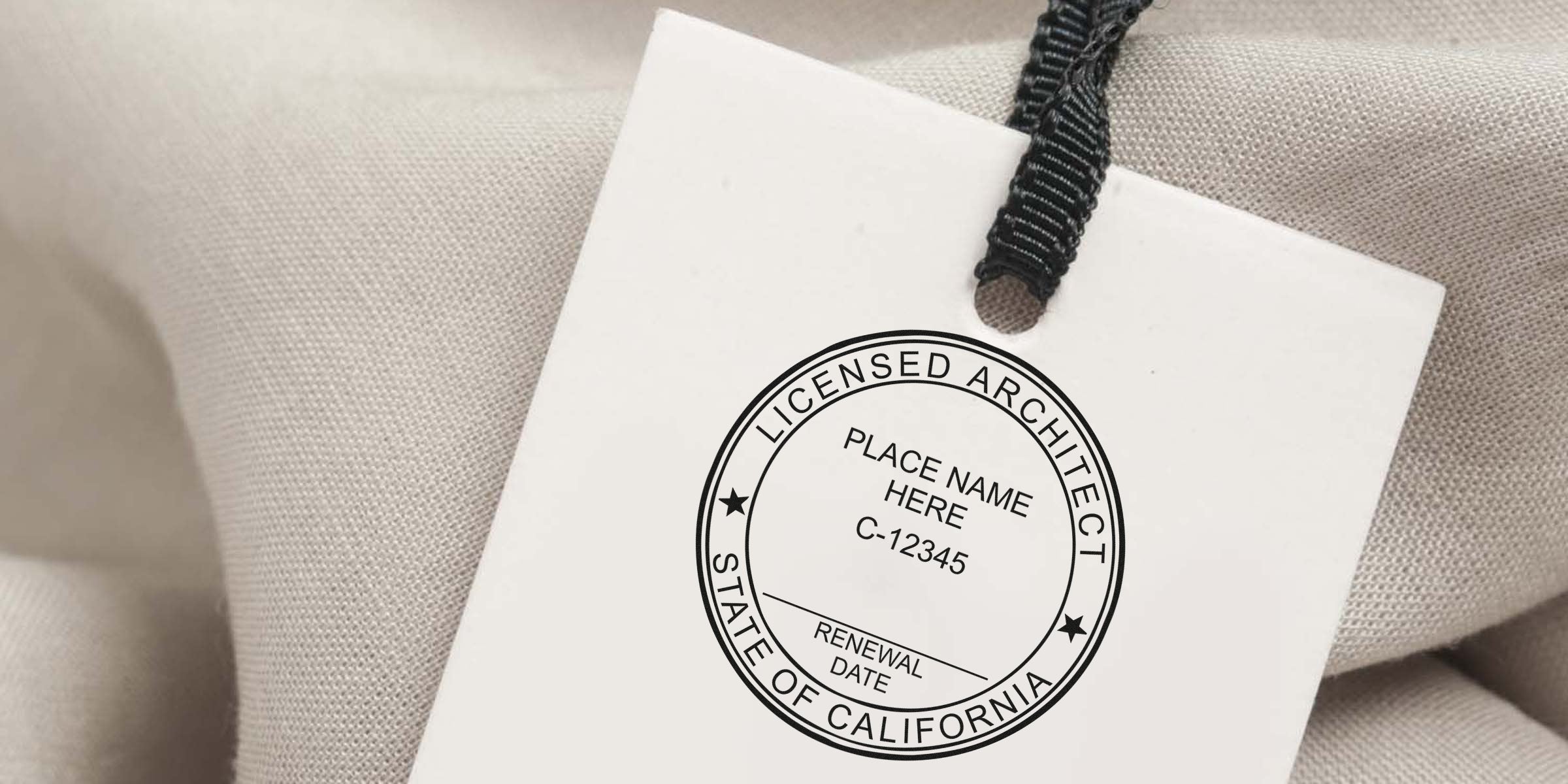 California architect seal stamp on white tag with black string, set on beige fabric, showing architect seal rules and a placeholder for license renewal date.