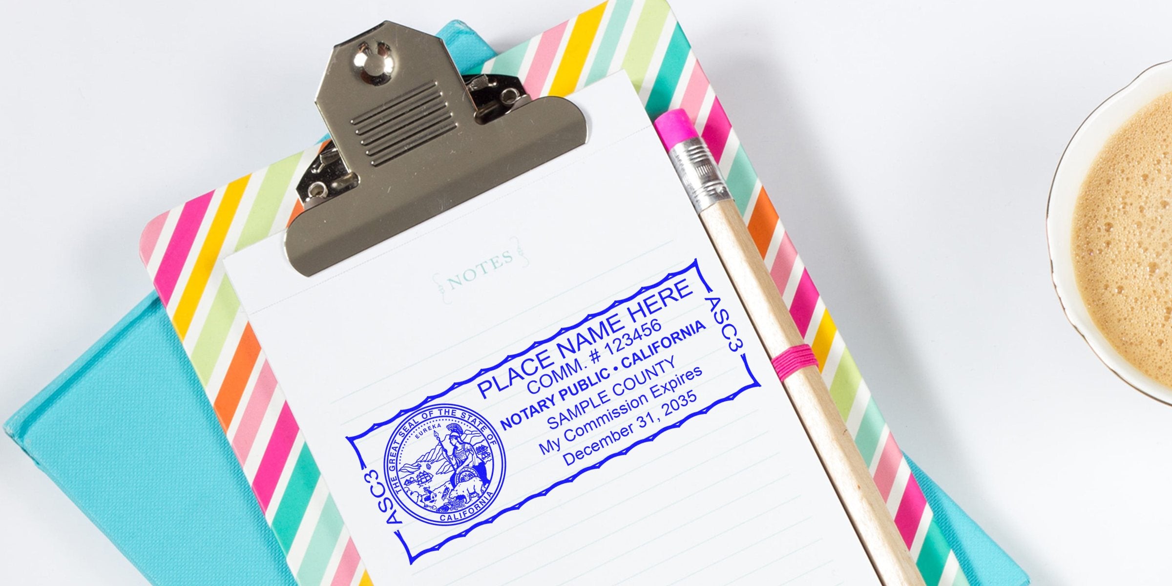 California notary stamp on clipboard with colorful border and pencil, showing commission seal and expiration date, on office desk with coffee cup and notary public stamp guide.