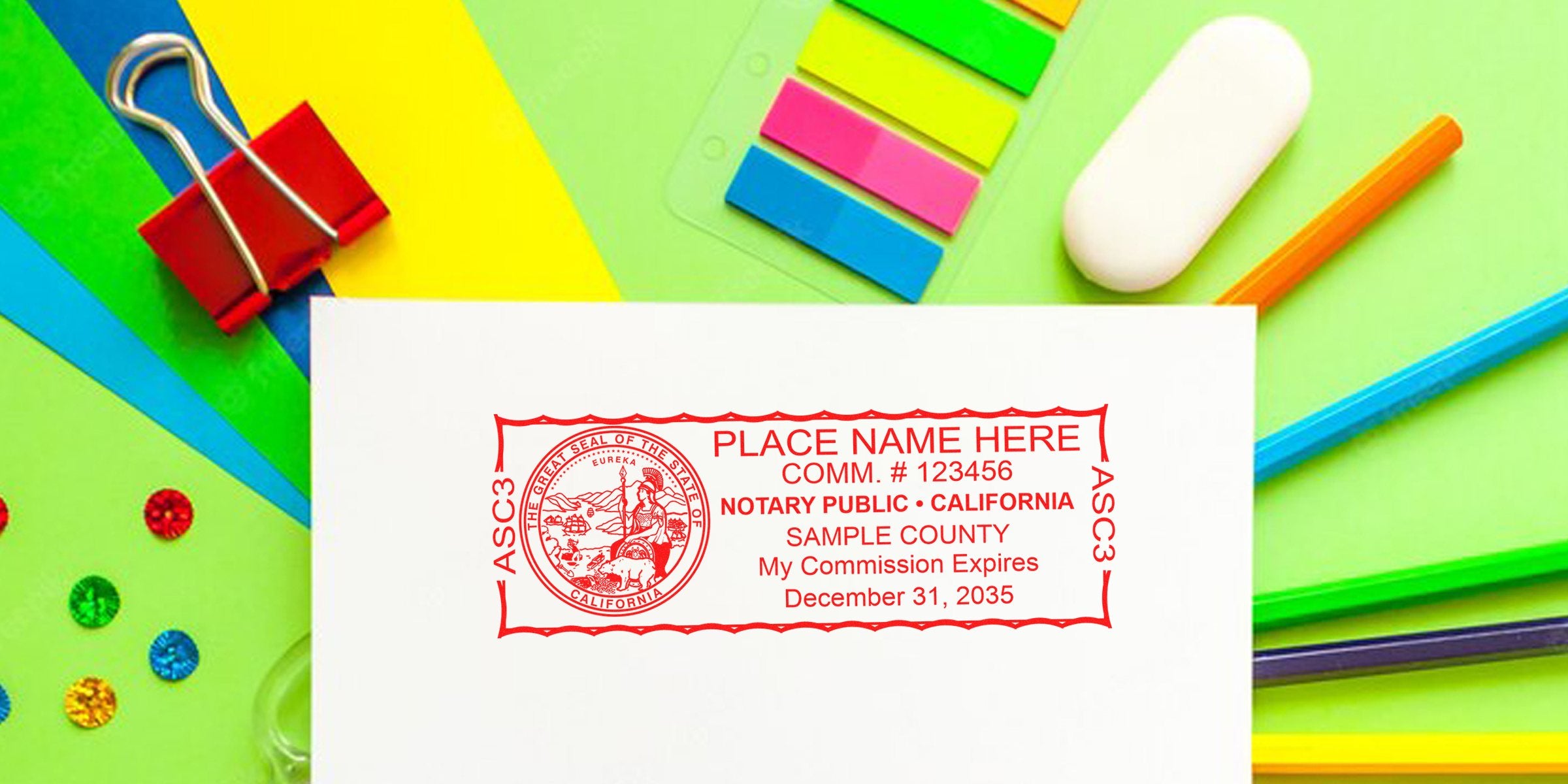 California notary public stamp with commission expiration date on white paper, surrounded by colorful CA notary supplies and tools.