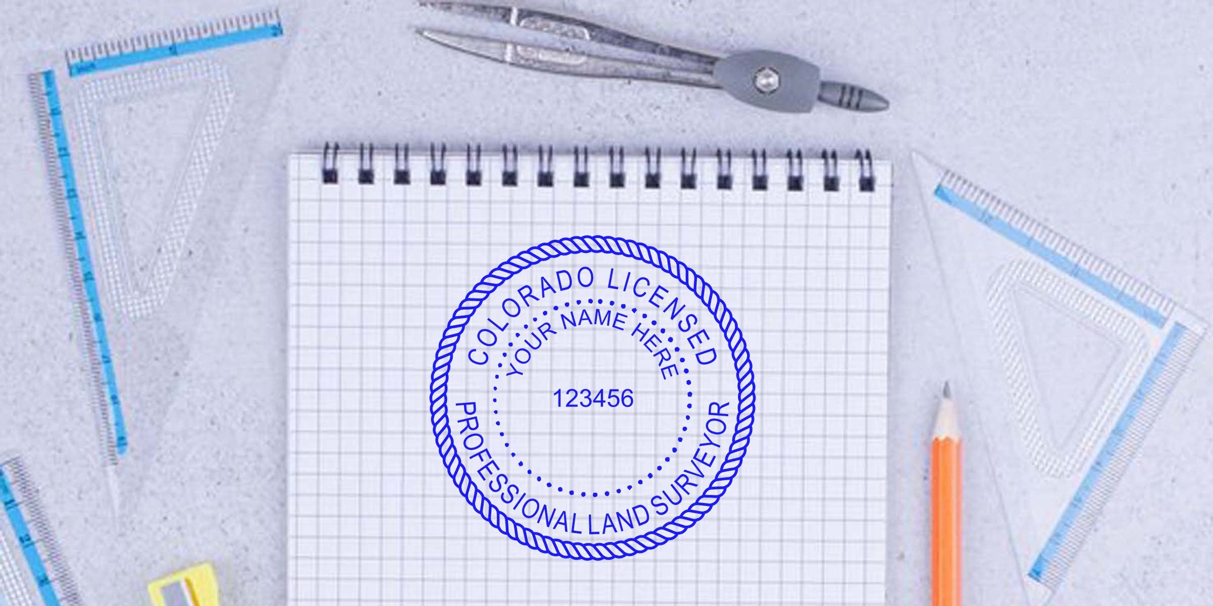 Colorado land surveyor stamp on graph paper with drafting tools and pencil, illustrating land surveying rules in Colorado.