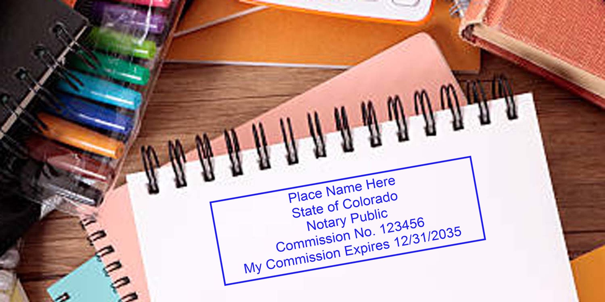 Colorado notary public stamp on spiral notebook with colorful pens and key notary supplies, ideal for new notary essentials.