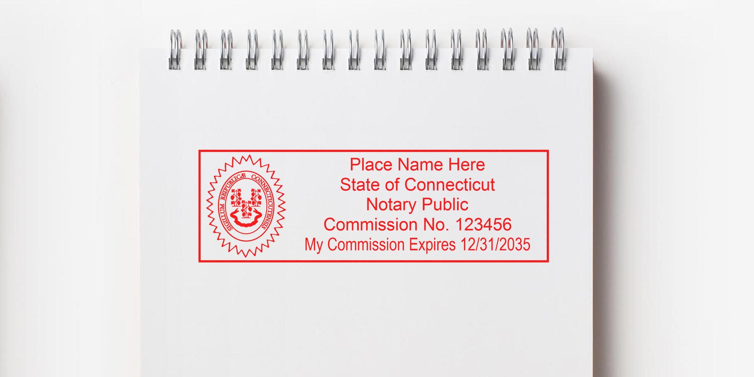 Red Connecticut notary stamp on white spiral notebook showing commission number and expiration date, complying with notary public seal regulations.