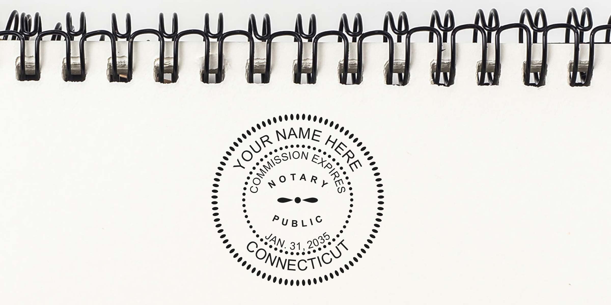 CT notary stamp on white spiral notebook showing official verification and commission expiration, perfect for those seeking a Connecticut notary stamp.