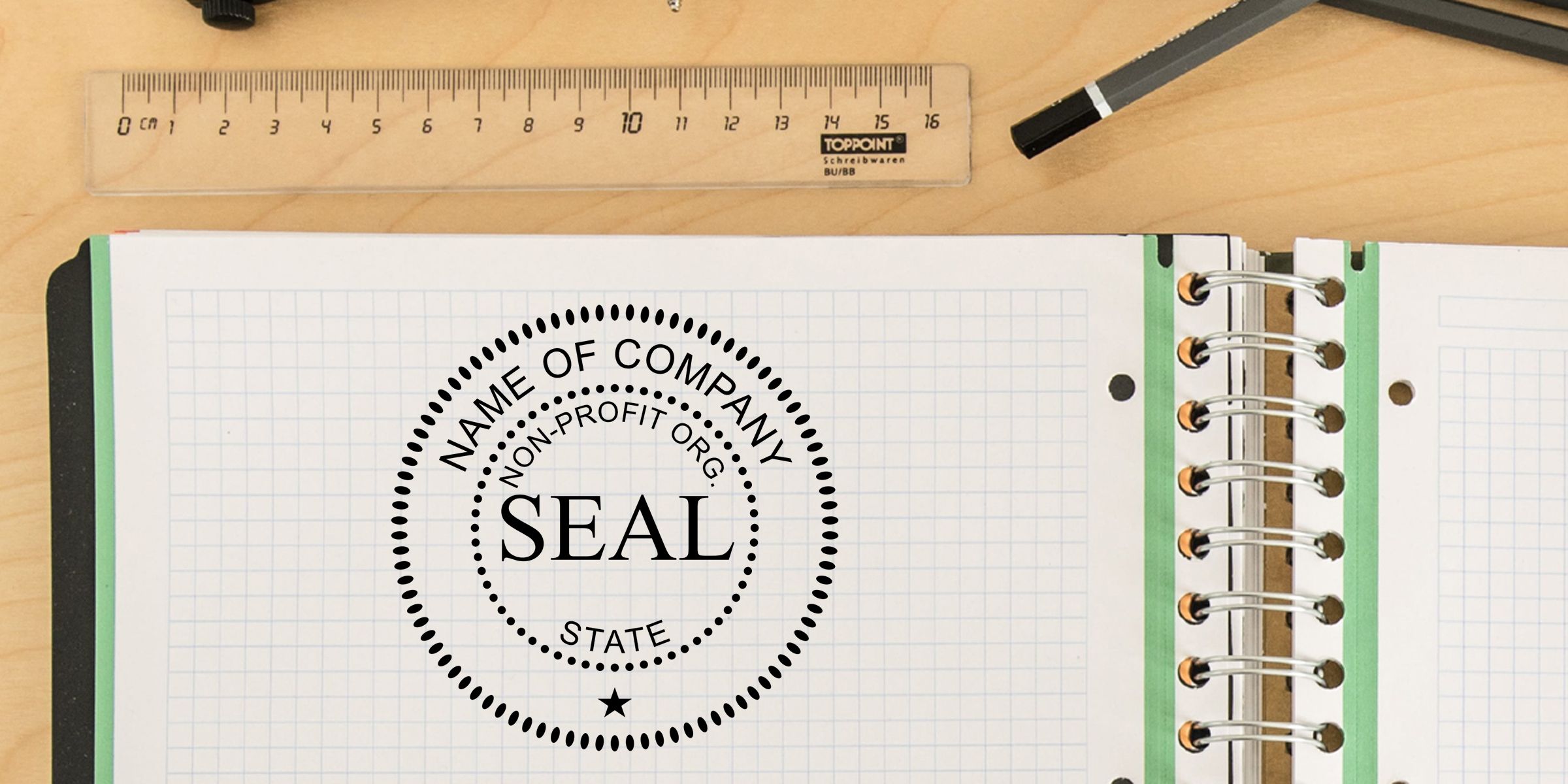 Notebook page with a nonprofit company seal stamp design, spiral binder notebook, ruler, and pen on a wooden desk, showing editable seal template for business branding and document authentication