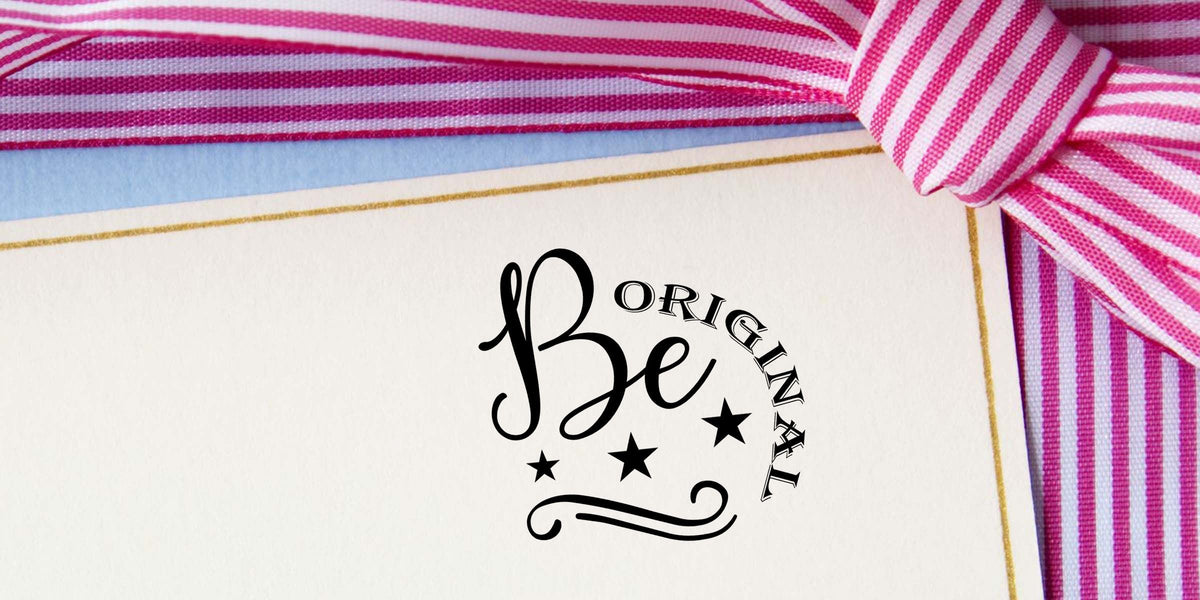 Pink and white striped ribbon on a cream gift card with gold border and Be Original logo branding.