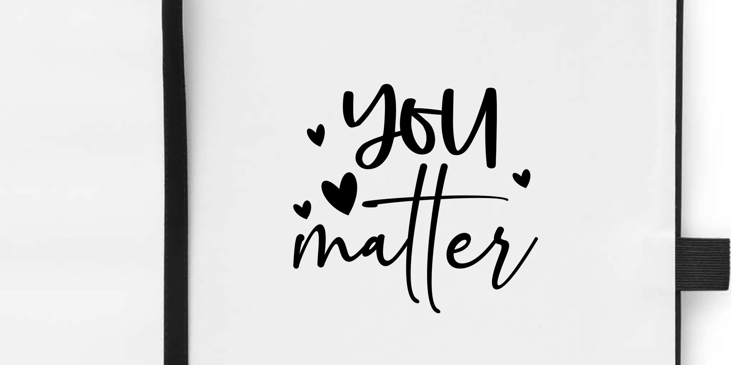 White notebook cover with black hand-lettered “You matter” quote and small heart accents, minimalist inspirational journal design
