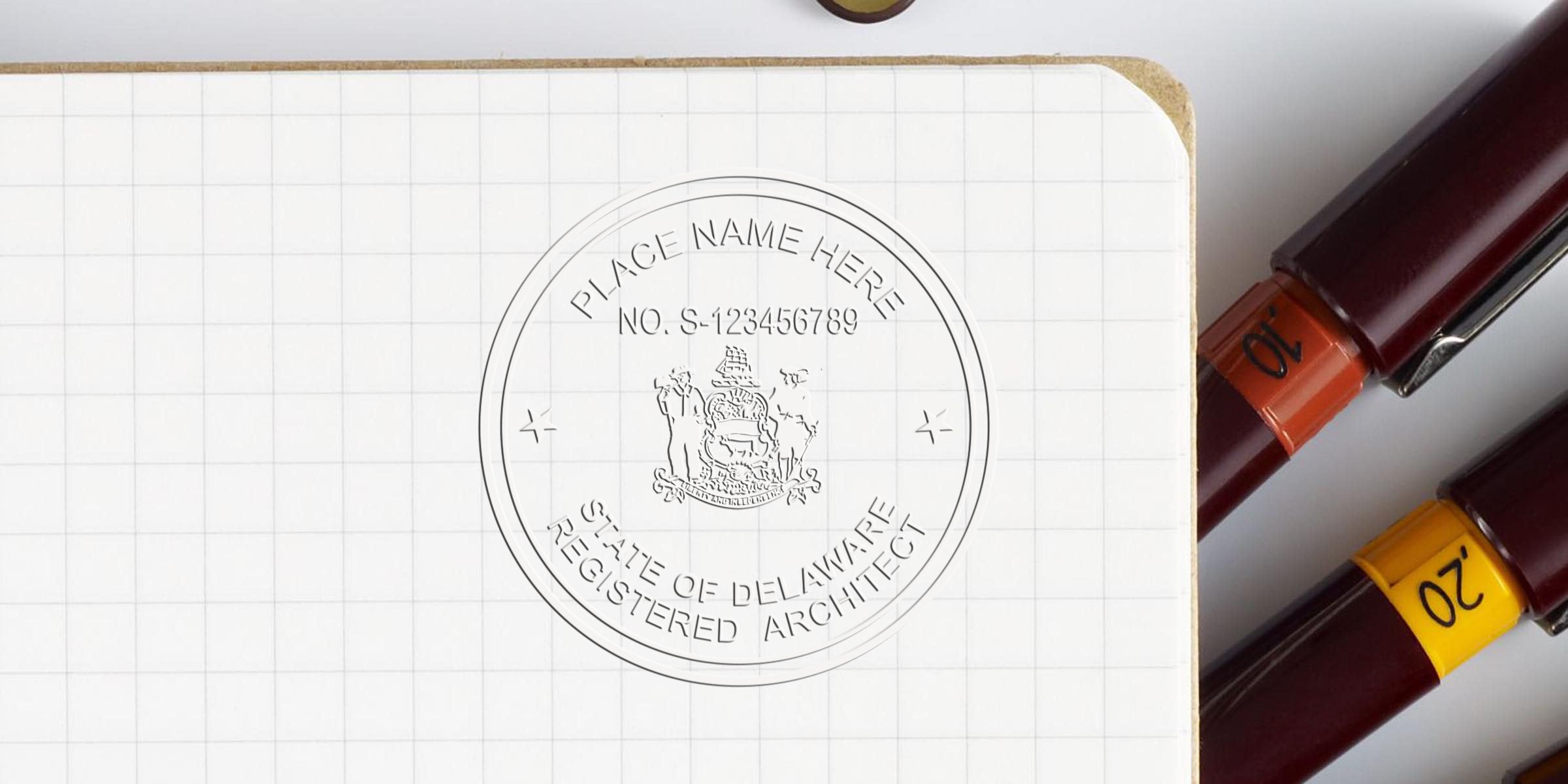Delaware architecture stamp seals on grid notebook with colored pens, displaying Delaware registered architect seal and meeting architectural stamp requirements.