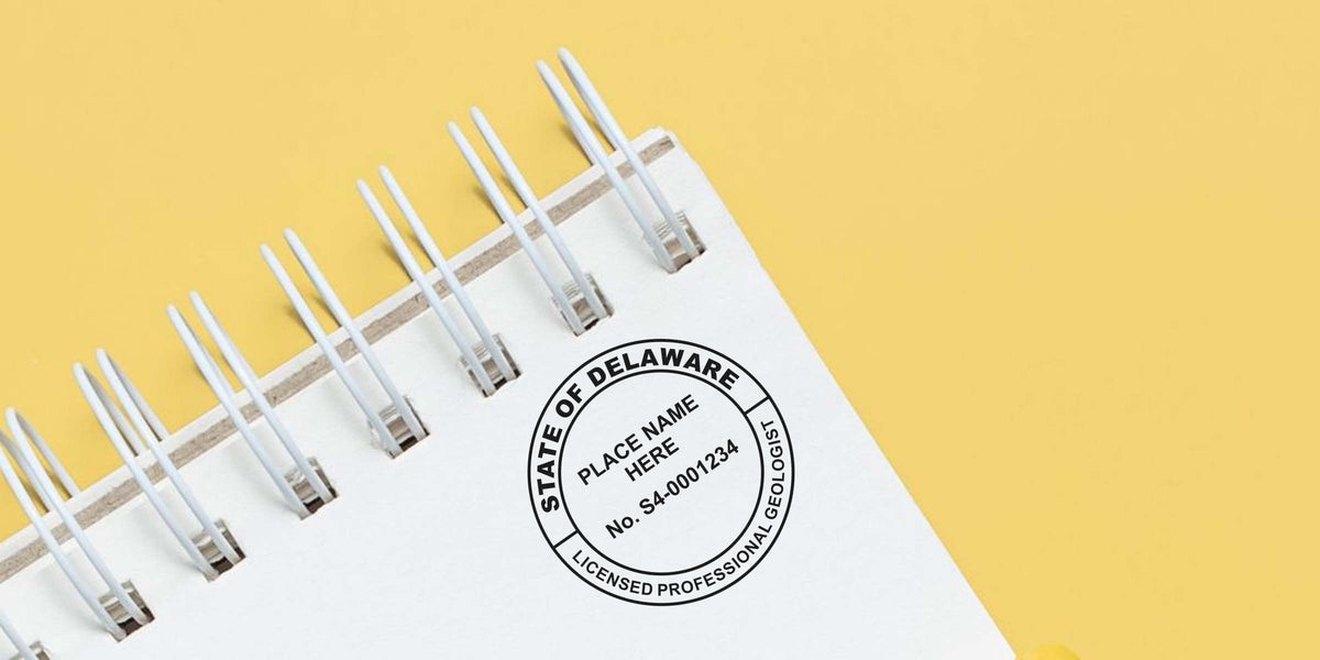 Delaware geologist stamp on white spiral notebook with yellow background, displaying the stamp and geologist stamp regulations.