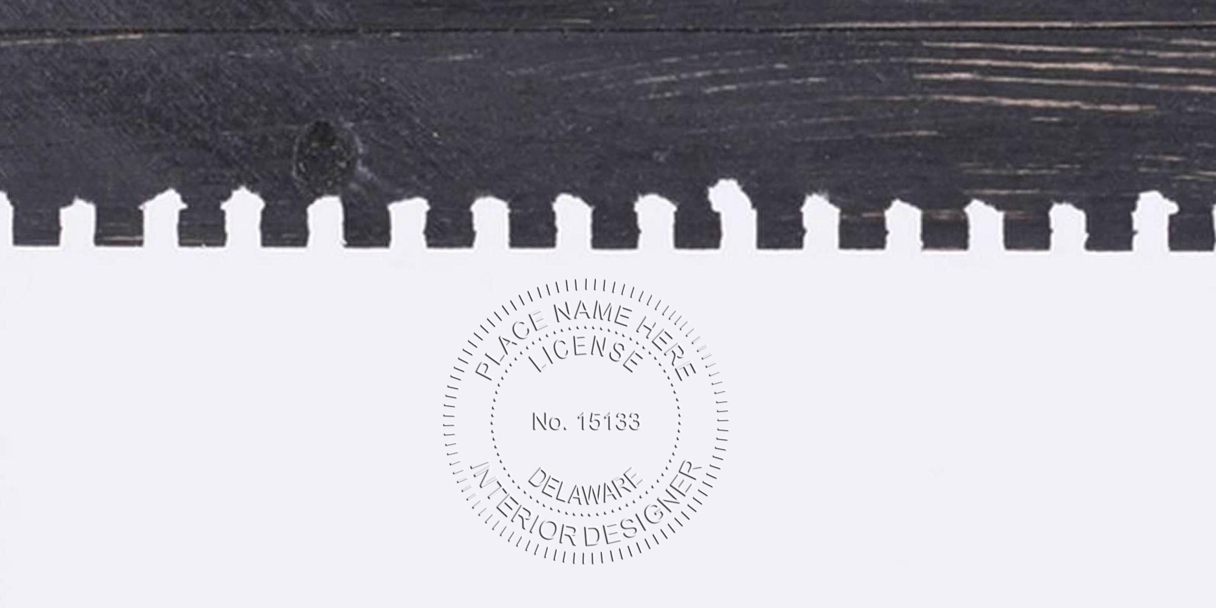 Interior Designer stamp on white paper against a black wooden background, highlighting the stamp application process.