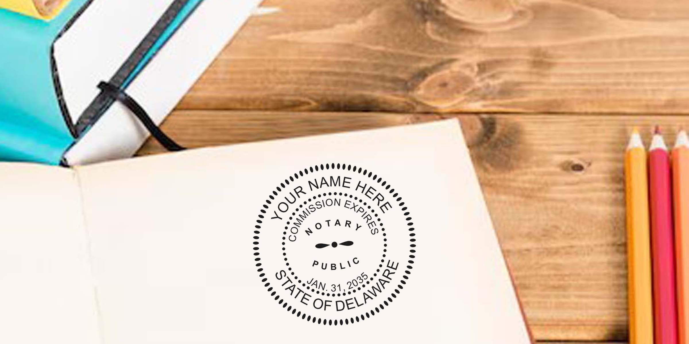 Delaware notary stamp on an open notebook with colored pencils and books on a wooden desk, showing an online Delaware notary stamp.