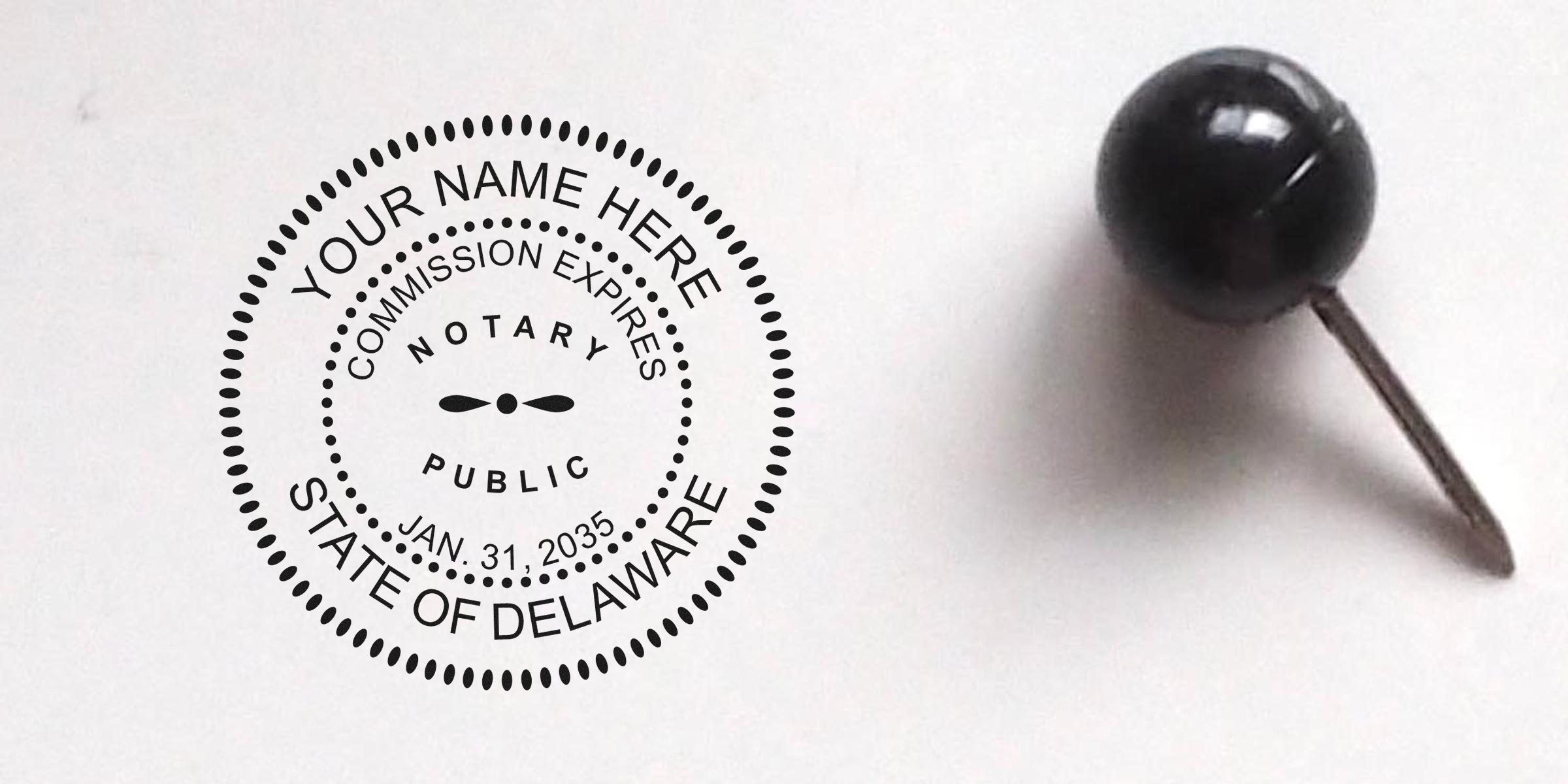 Delaware notary stamp with commission expiration date pinned by a black push pin on a white background, showing the process of becoming a notary.