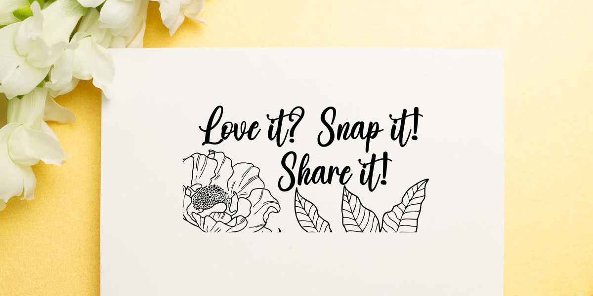 Elegant floral social media quote card with white flowers and handwritten text reading “Love it! Snap it! Share it!”