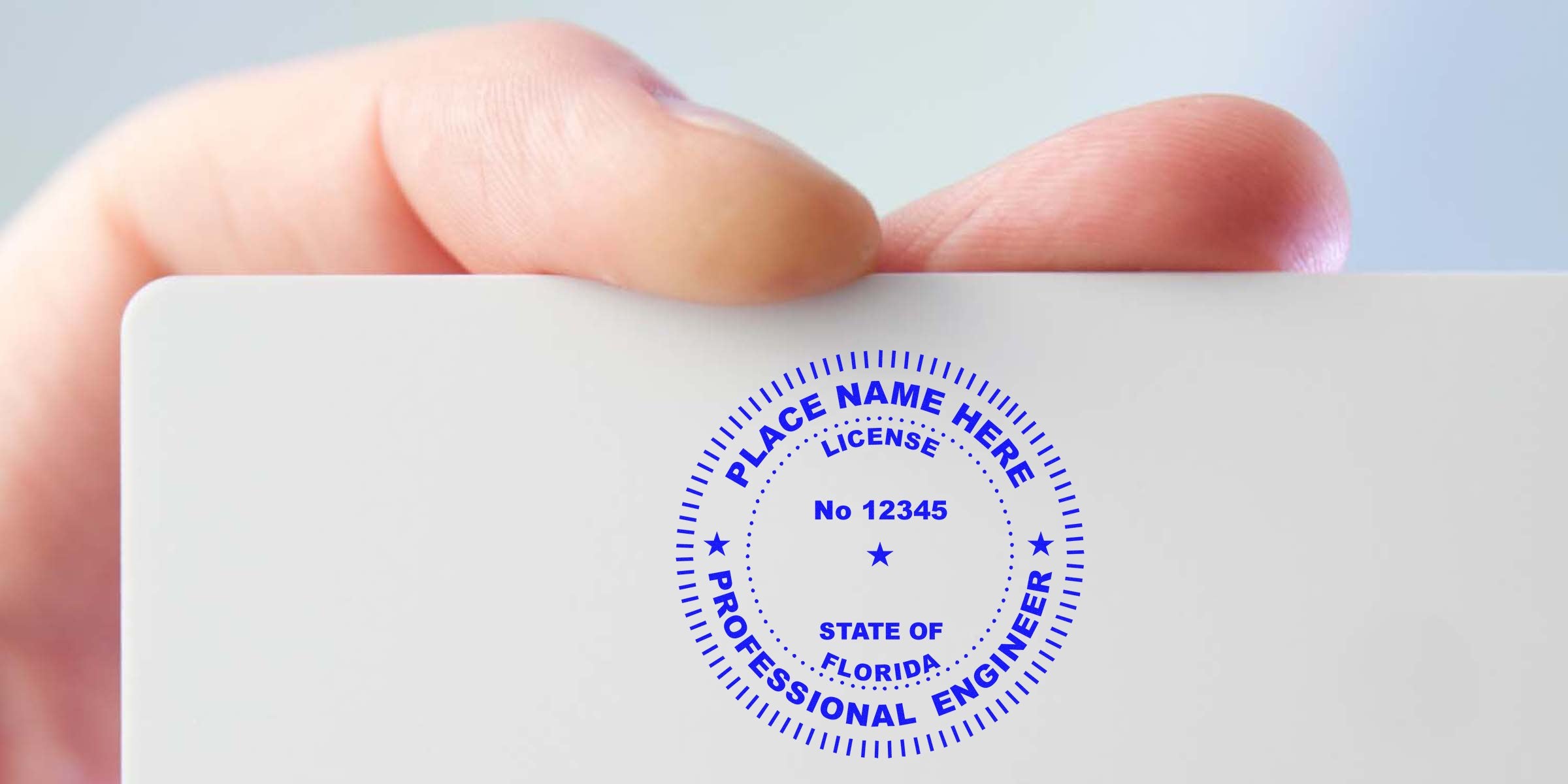 Hand holding Florida engineer license card with official stamp and seal, highlighting quick engineer stamp verification.