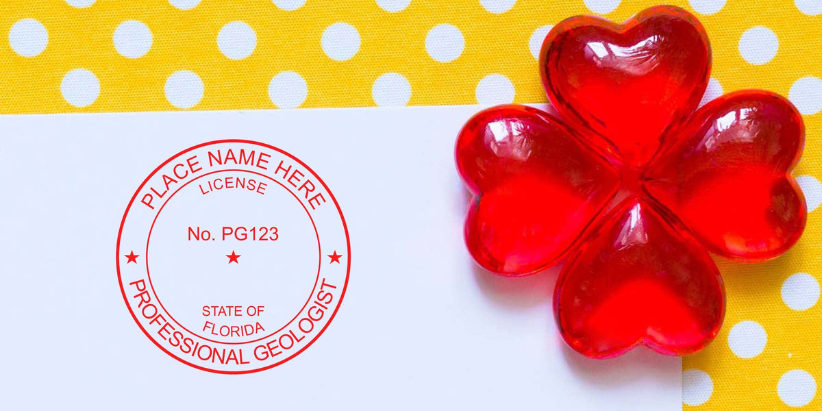 Red geologist license stamp on white paper with red heart decorations on yellow polka dots, showing Florida Geologist Stamp Size and Requirements.