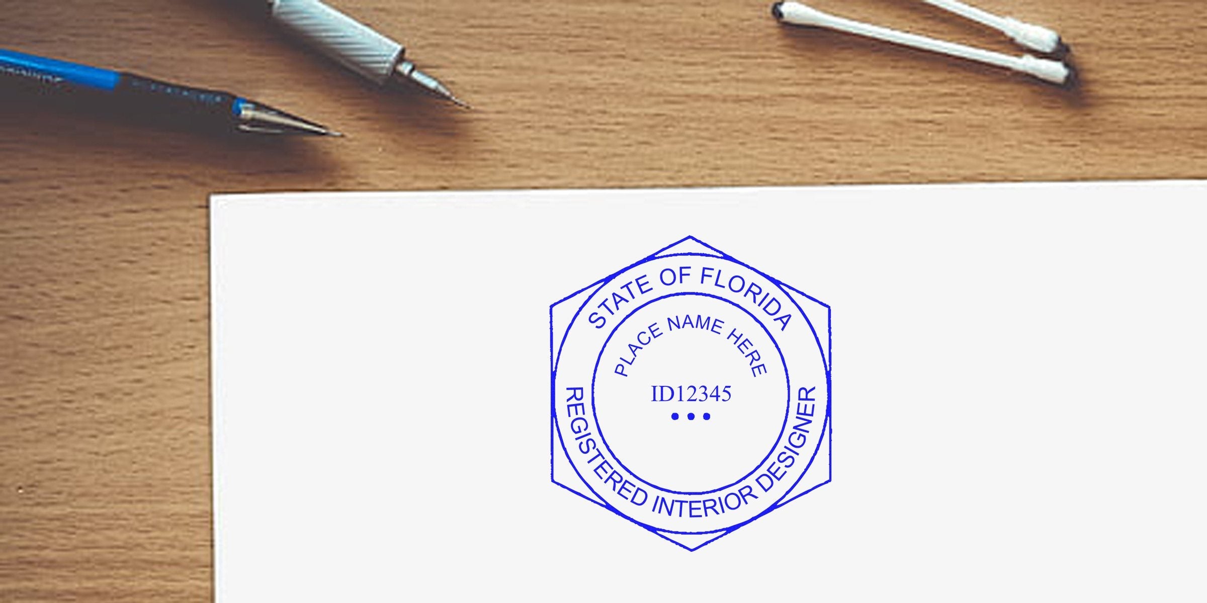 Florida interior designer seal embossed on white paper with pens and cotton swabs on a wooden desk, highlighting official certification and a simplified embossing process.