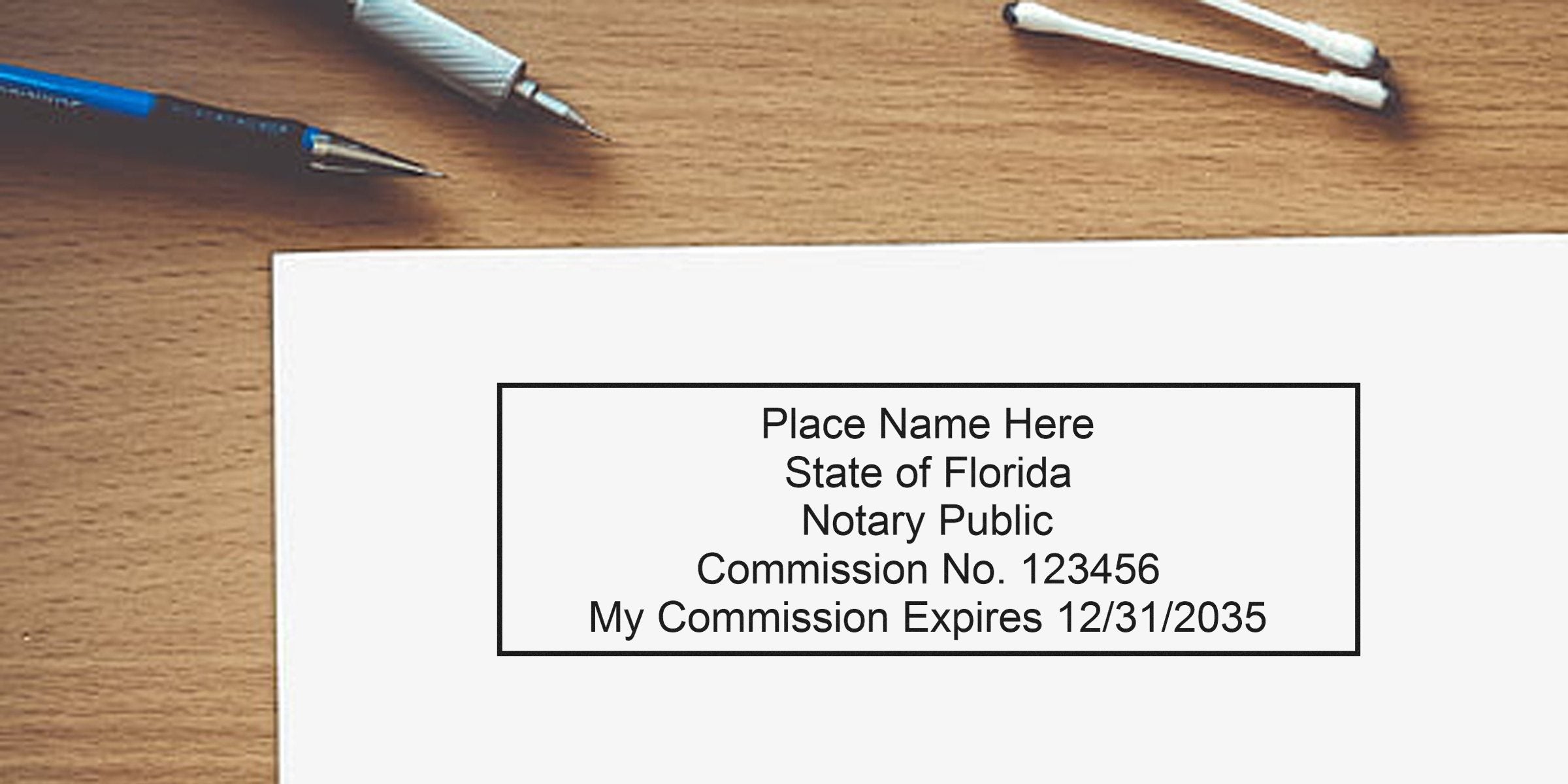 Florida notary public commission certificate with expiration date on wooden desk, alongside pens and cotton swabs, showcasing essential Florida notary supplies for your shopping guide.