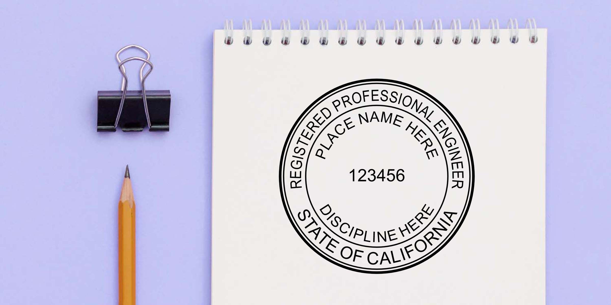 California professional engineer seal stamp on a spiral notebook with a pencil and binder clip on a lavender background