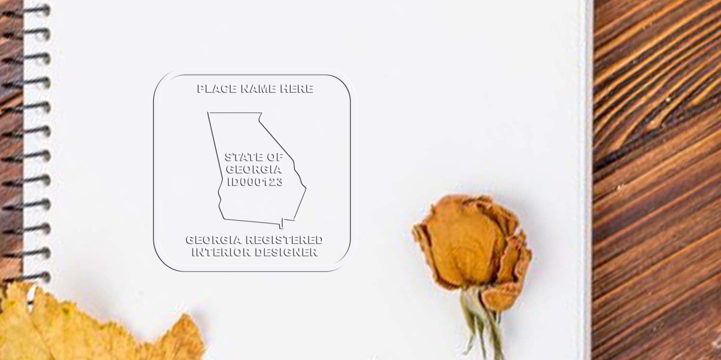 Georgia interior designer seal on notebook with dried flower, wooden table background, showing seal size details.