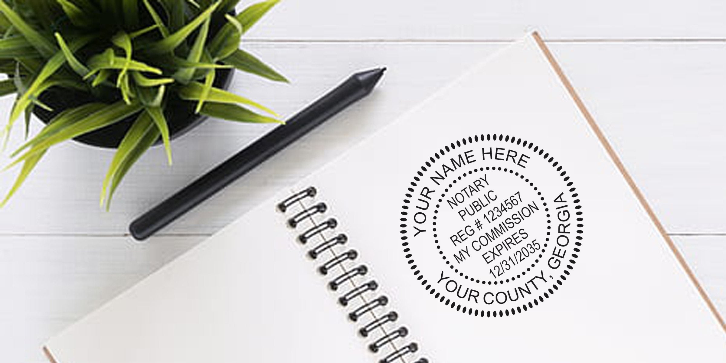 Affordable Georgia notary supplies, including personalized notary stamps and seals for official documents, displayed with a notebook, pen, and plant.