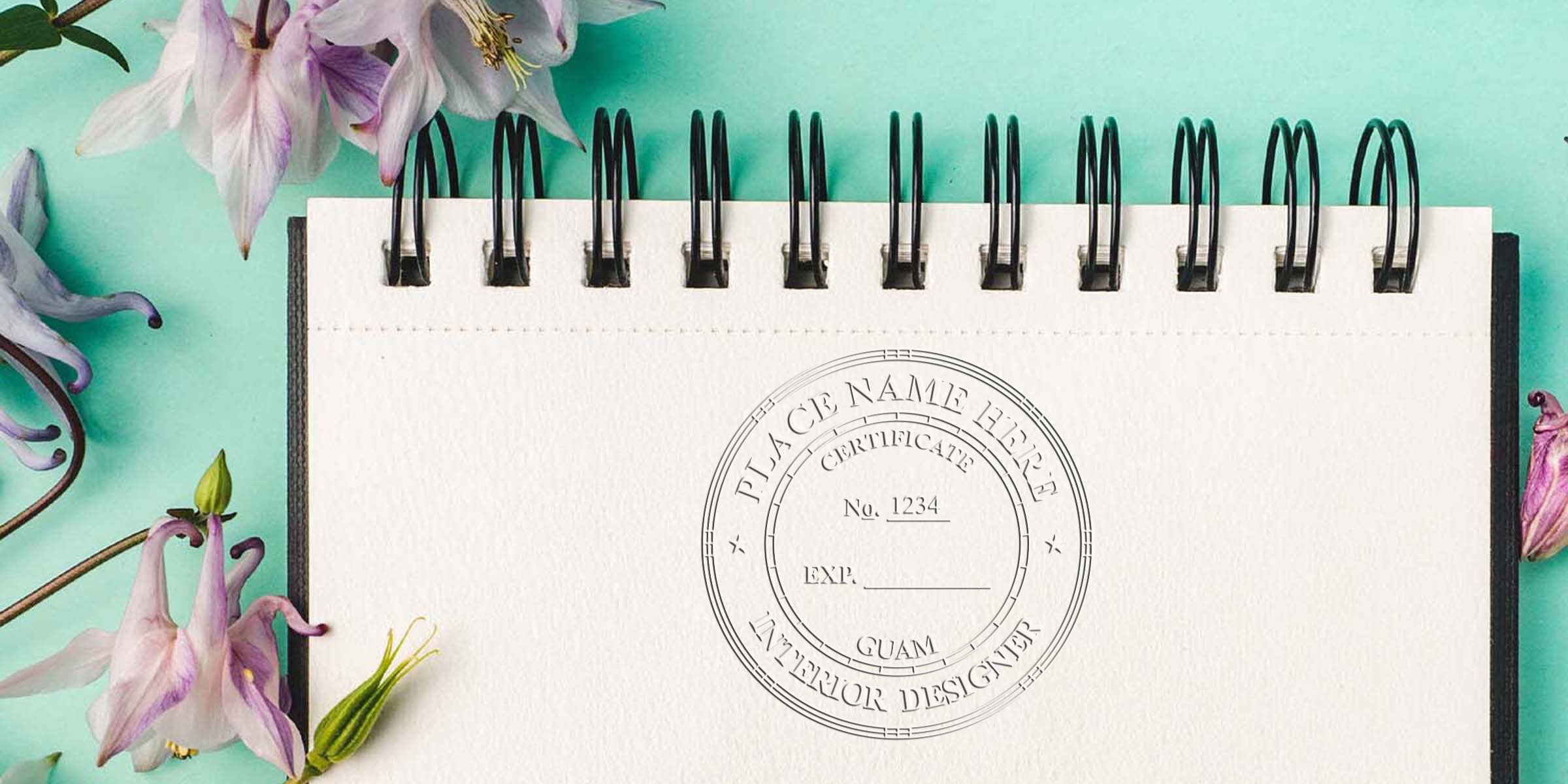 Blank spiral notebook with Guam interior designer stamp and certificate, surrounded by purple flowers on a turquoise background, showing the stamp application process.