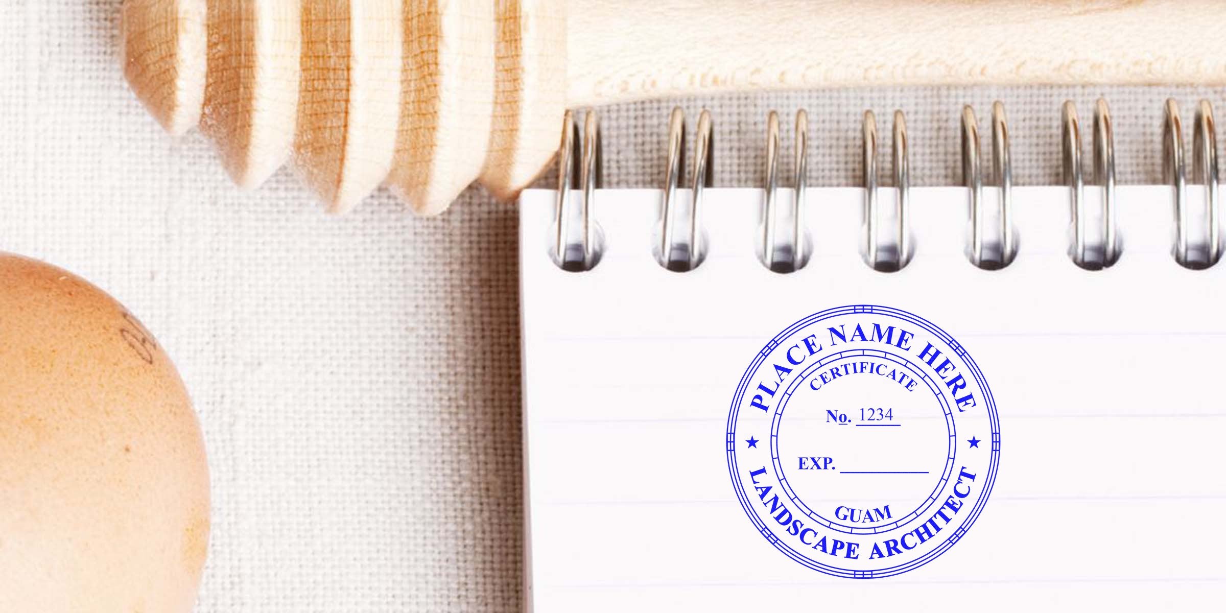 Wooden honey dipper beside an egg and a spiral notebook showing a Guam landscape architect certificate with a seal design.