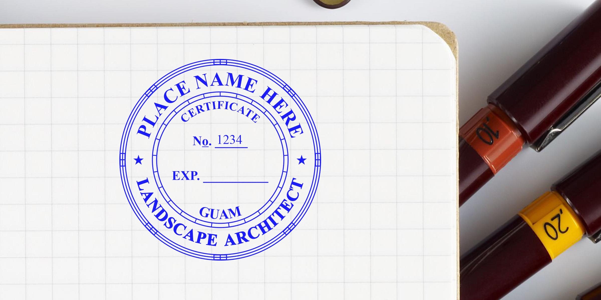 Blue custom landscape architect stamp on grid paper with pens nearby, highlighting Guam landscape design.