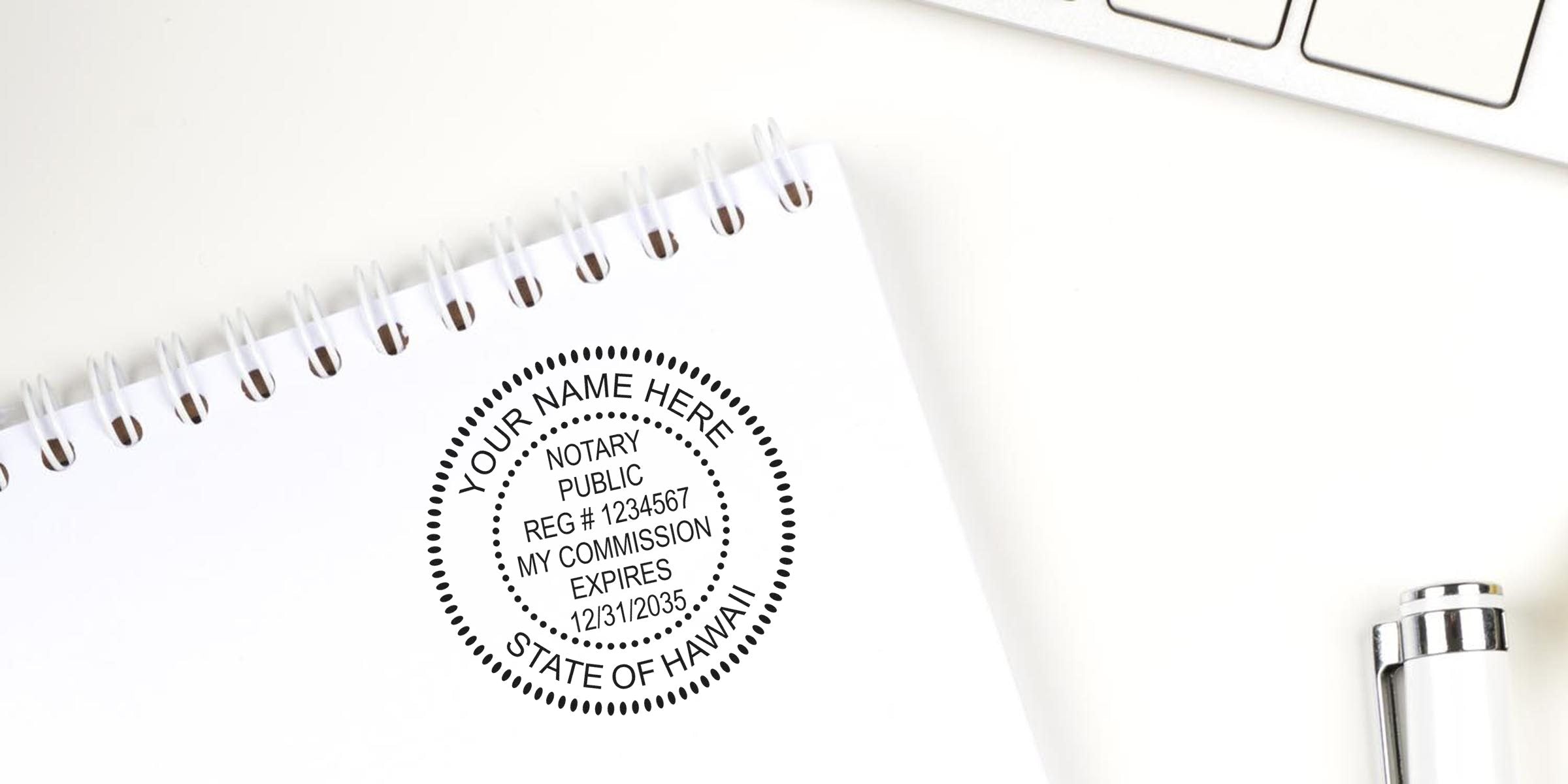 Custom Hawaii notary stamp on white spiral notebook with pen and keyboard, personalized seal for official documents, featured in Hawaii notary stamp guide.