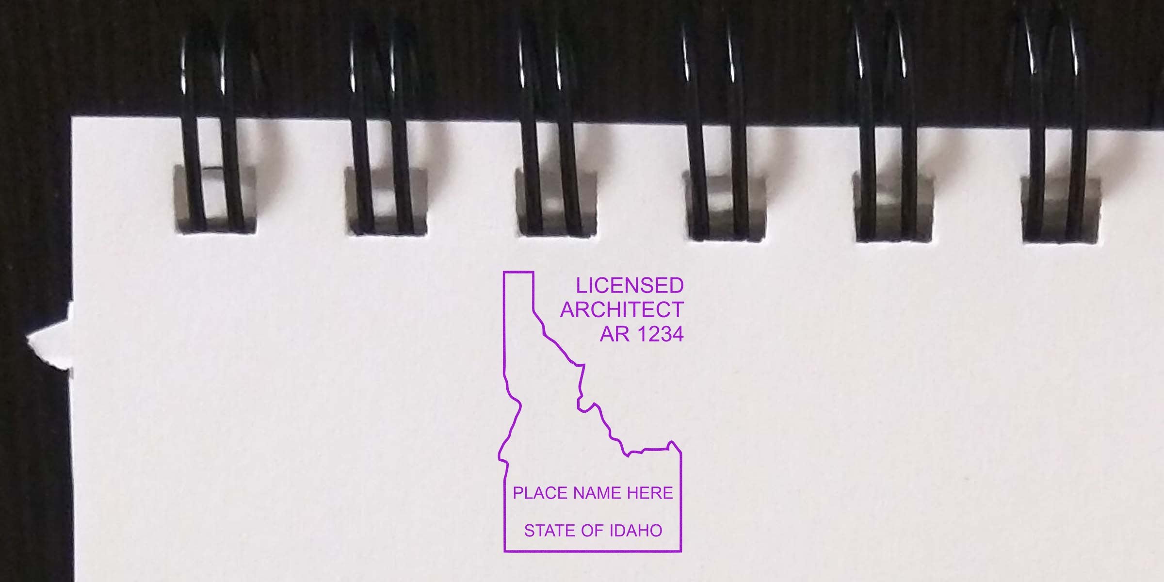 Idaho architect’s self-inking stamp on white spiral-bound paper, showing the official Idaho licensed architect seal.