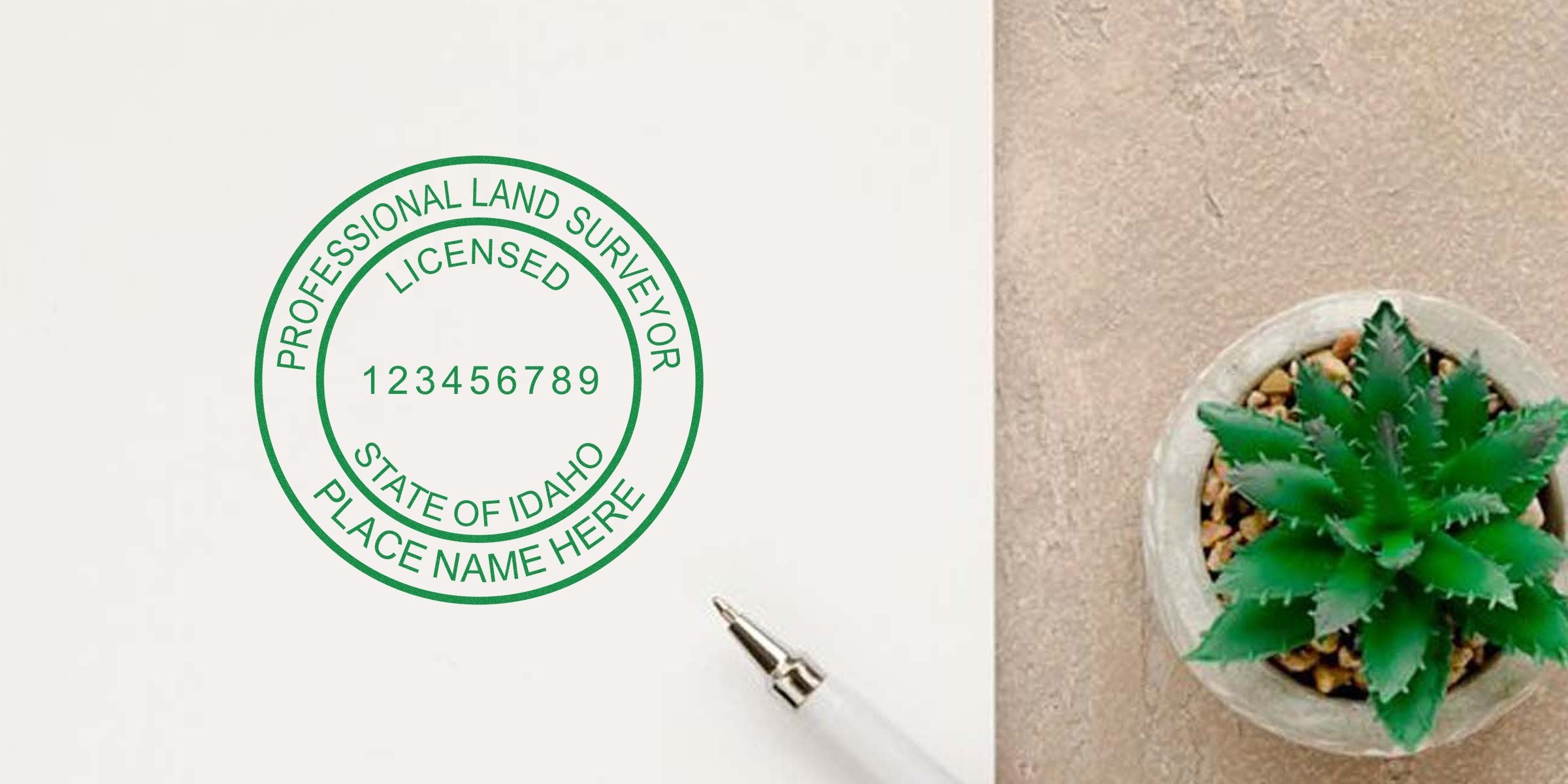 Idaho land surveyor stamp with pen and green succulent on desk, symbolizing professional land surveyor certification in Idaho.