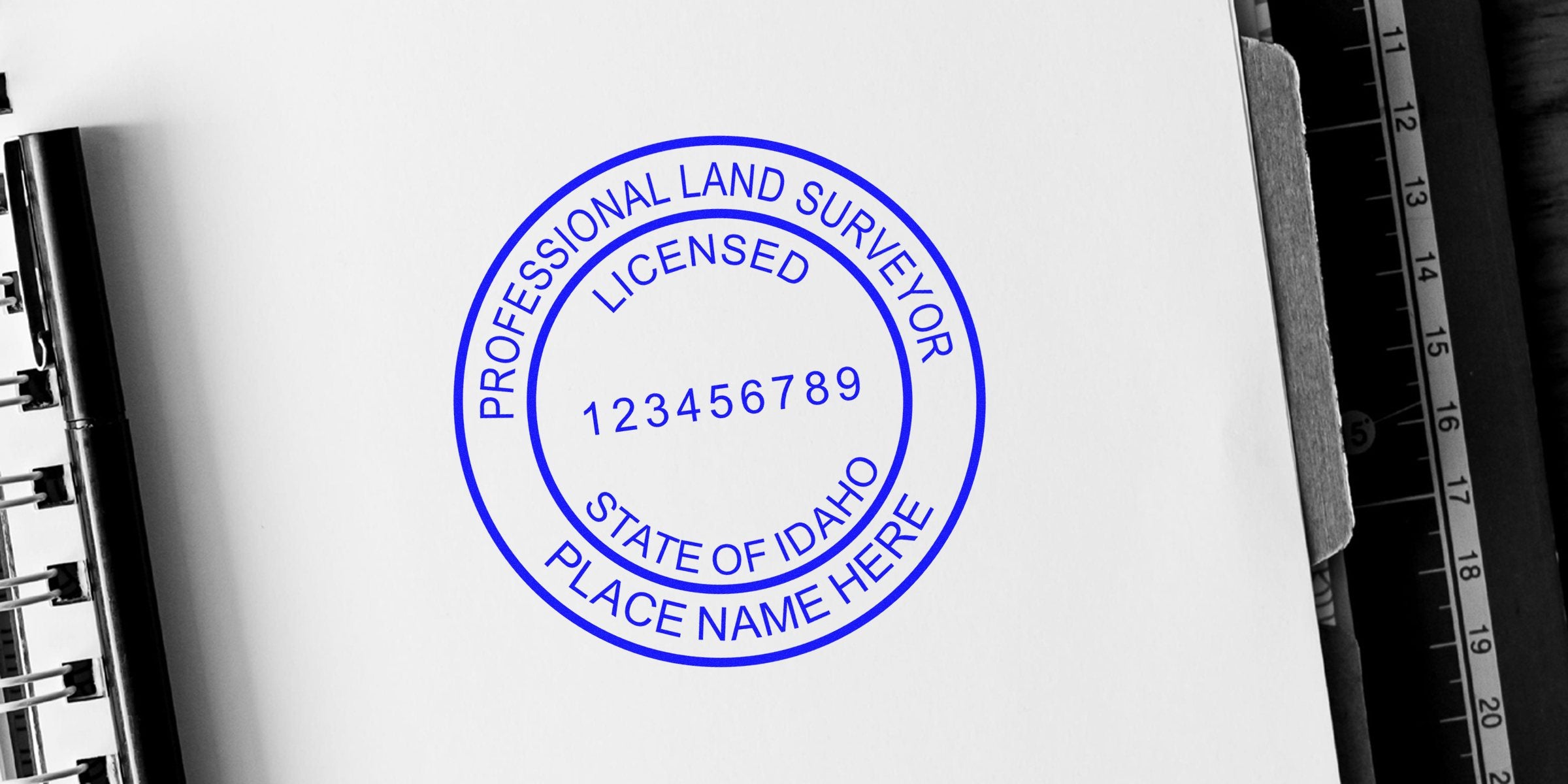 Idaho land surveyor stamp on white paper with ruler and notebook, showing official surveyor seal and professional Idaho land surveying certification.