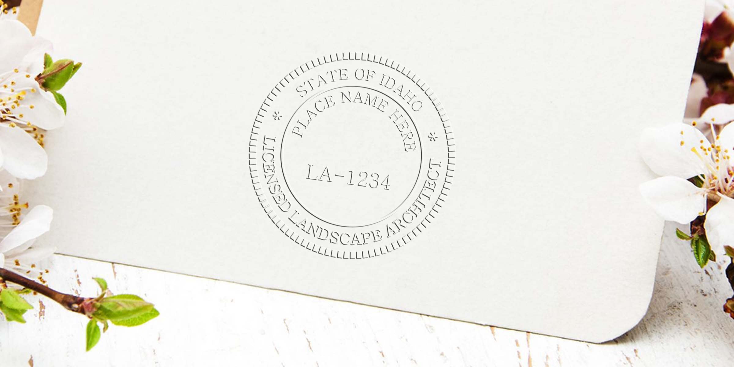 Embossed Idaho landscape architect stamp on white paper with spring flowers, showing certification seal LA-1234 and Idaho landscape architect licensing details.