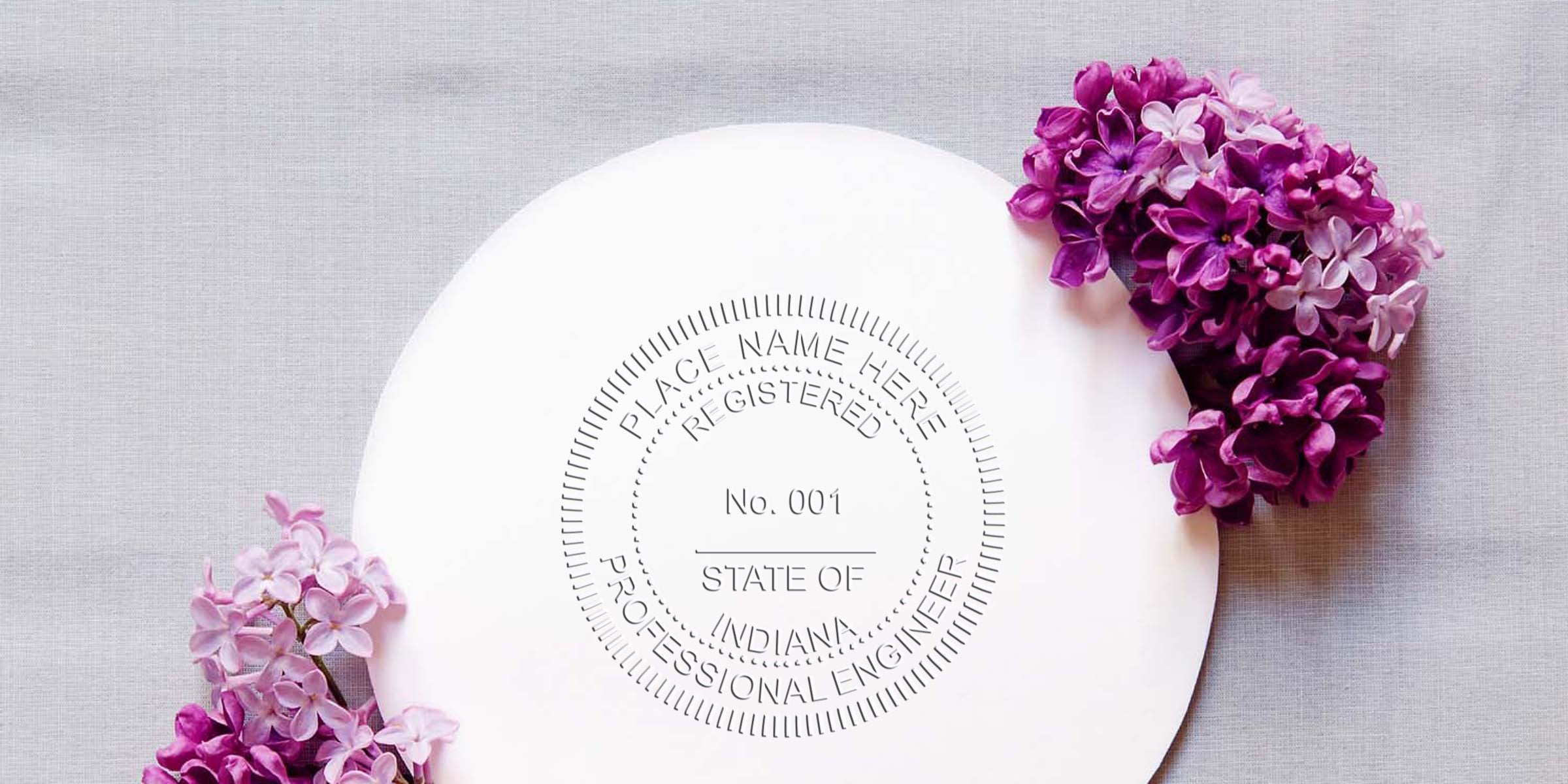 Indiana engineer stamp with pro engineer seal, purple lilac flowers on gray fabric, and engineer embosser tool.
