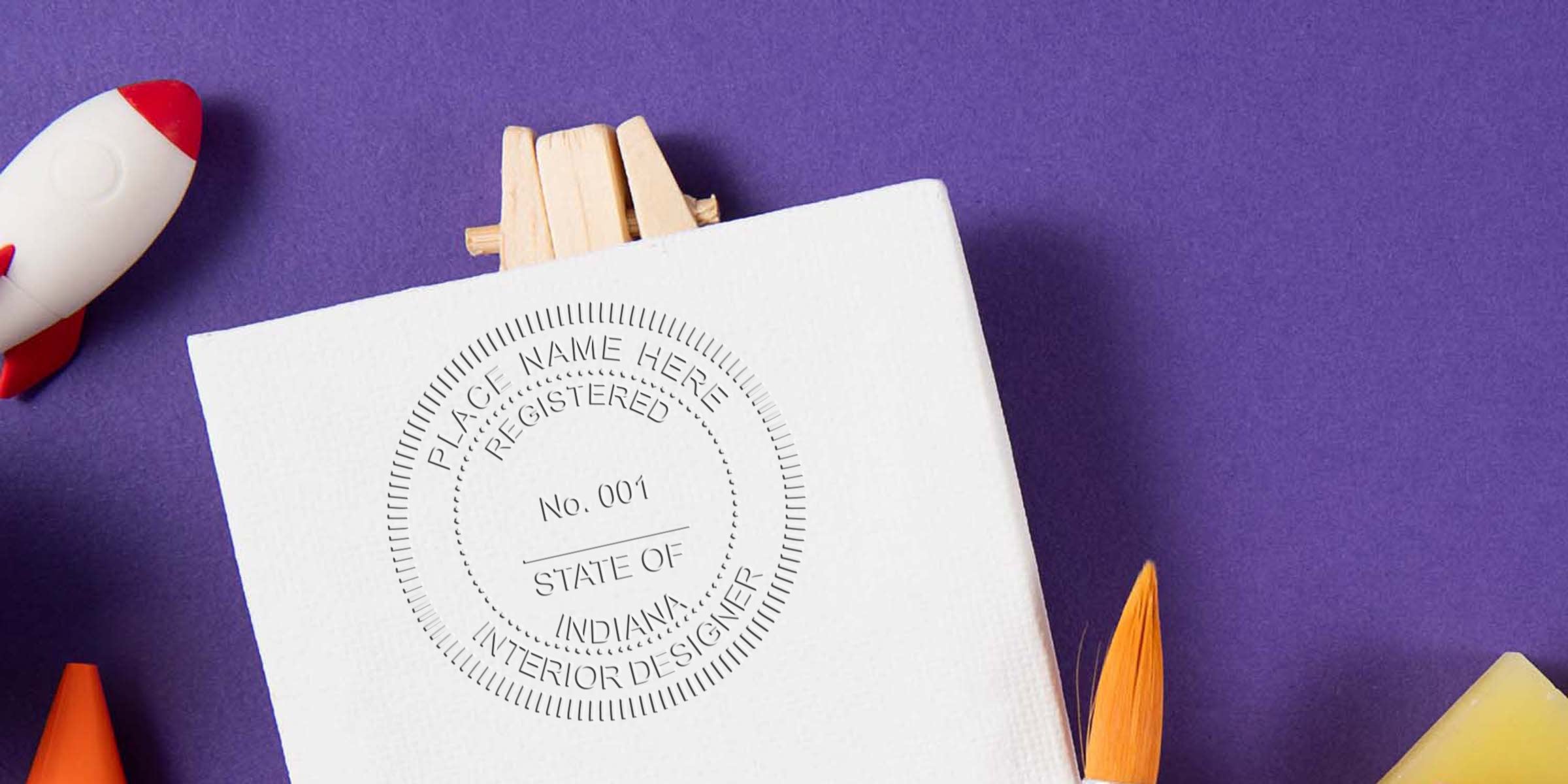 Custom embossed seal on white canvas showing Indiana interior design rules and licensing, with creative painting tools and a rocket on a purple background.