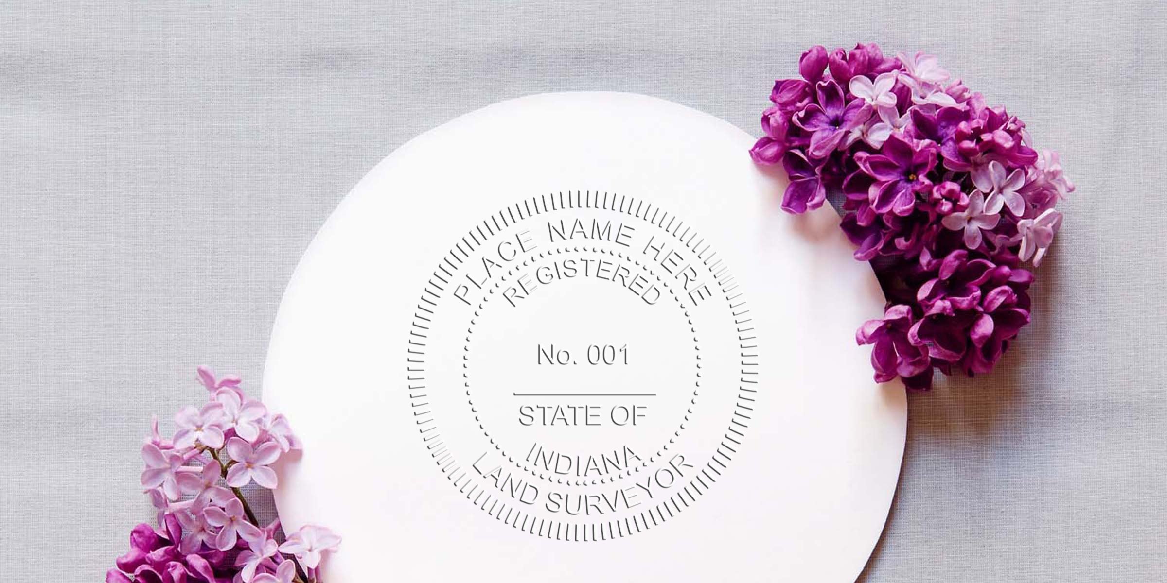 Indiana land surveyor seal with purple lilac flowers on gray fabric, highlighting Indiana land surveyor costs and surveyor stamp fees.