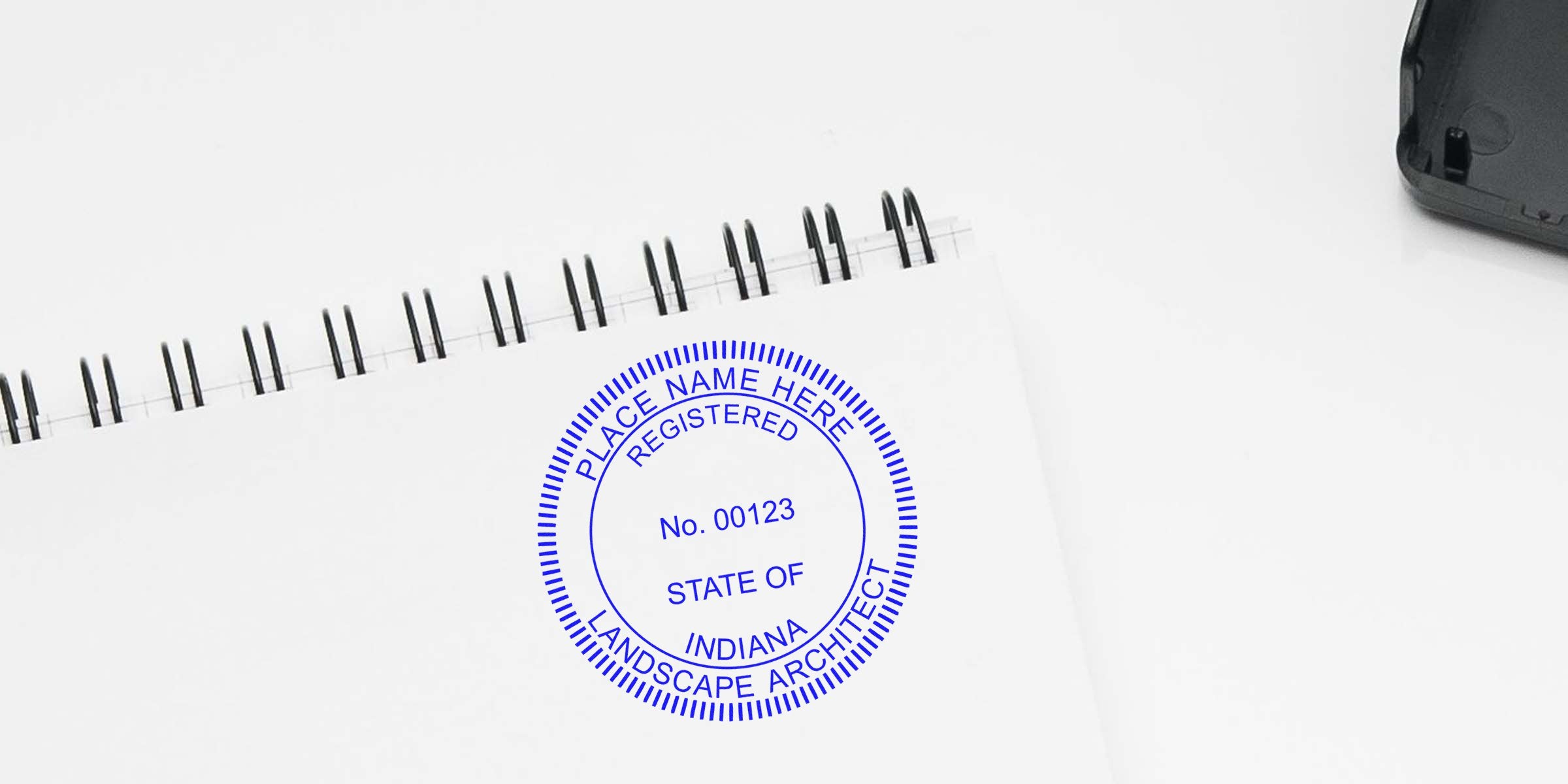 Indiana landscape architect registered seal stamp on white spiral notebook, with info on certification verification, stamp cost, and fees for Indiana landscape architects.