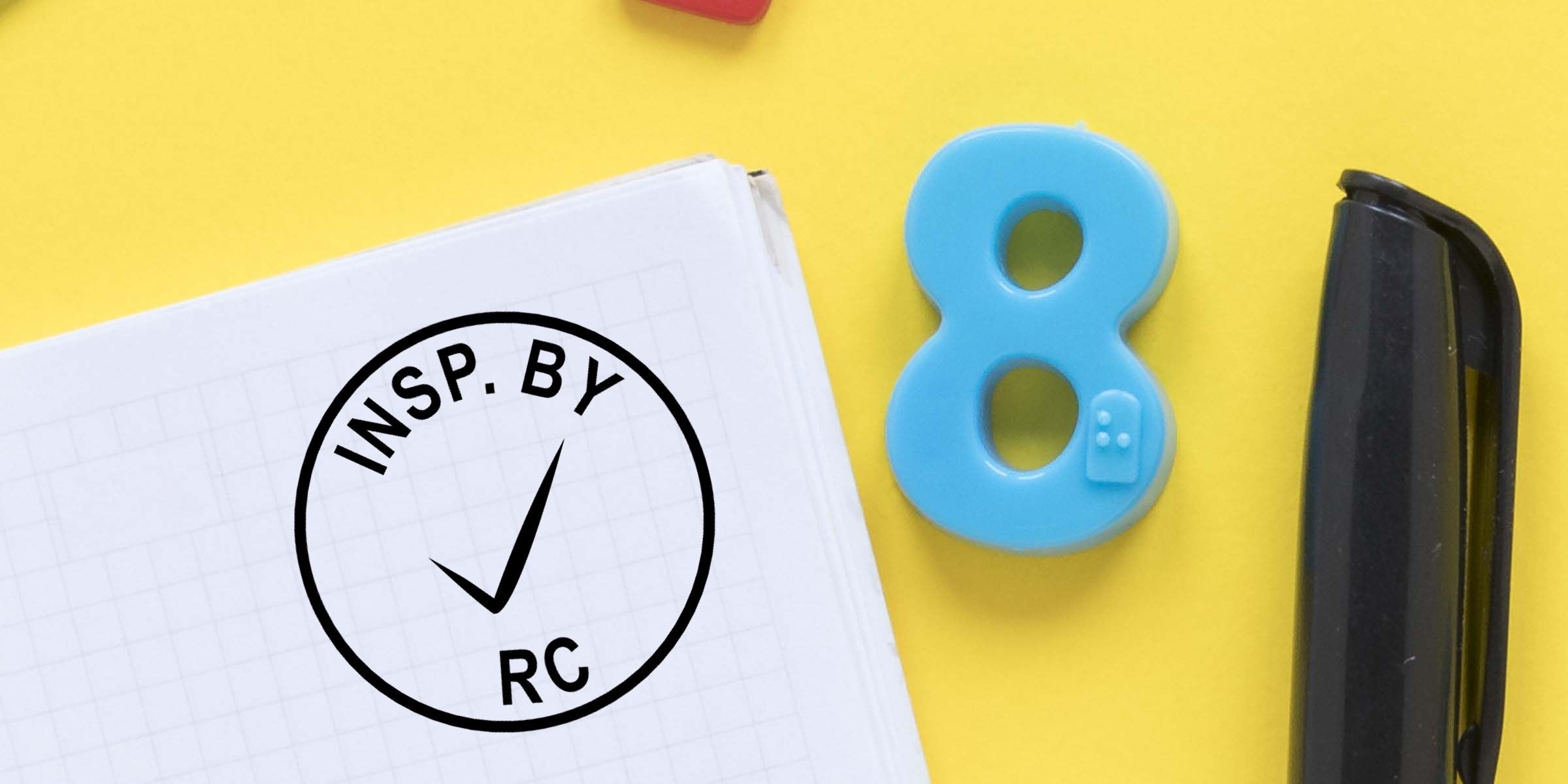Notebook with INSP.BY RC checkmark logo, blue number 8, and black stapler on a yellow background, representing creative office stationery and branding concept
