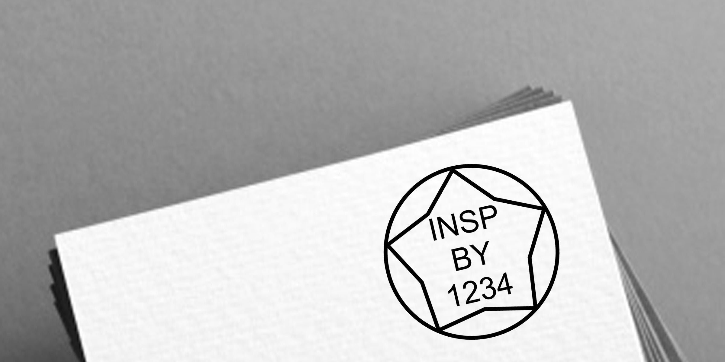 Stack of white business cards with a black circular logo reading “INSP BY 1234” on a gray background