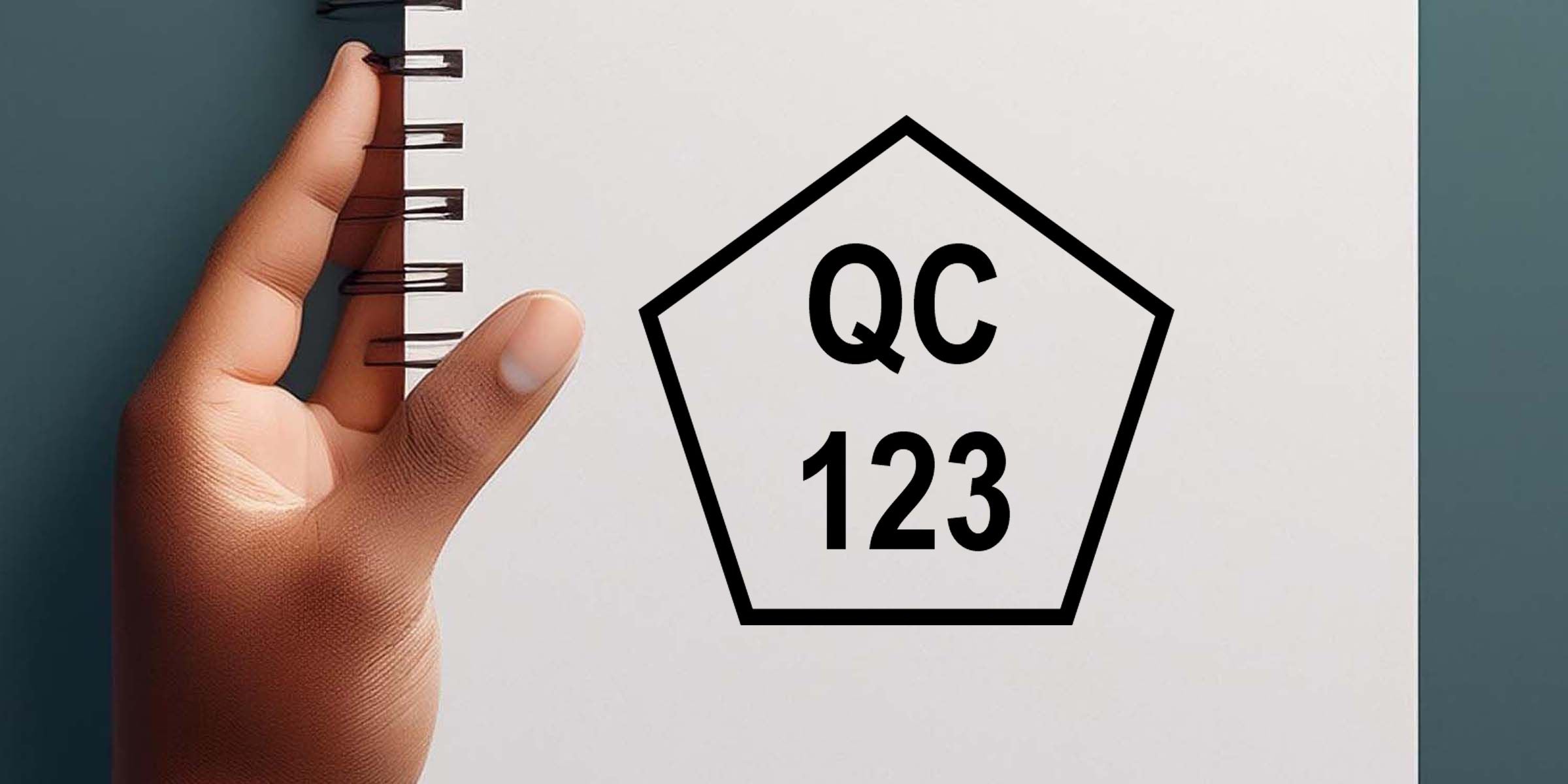 Hand holding a spiral notebook with a QC 123 quality control icon on a white page