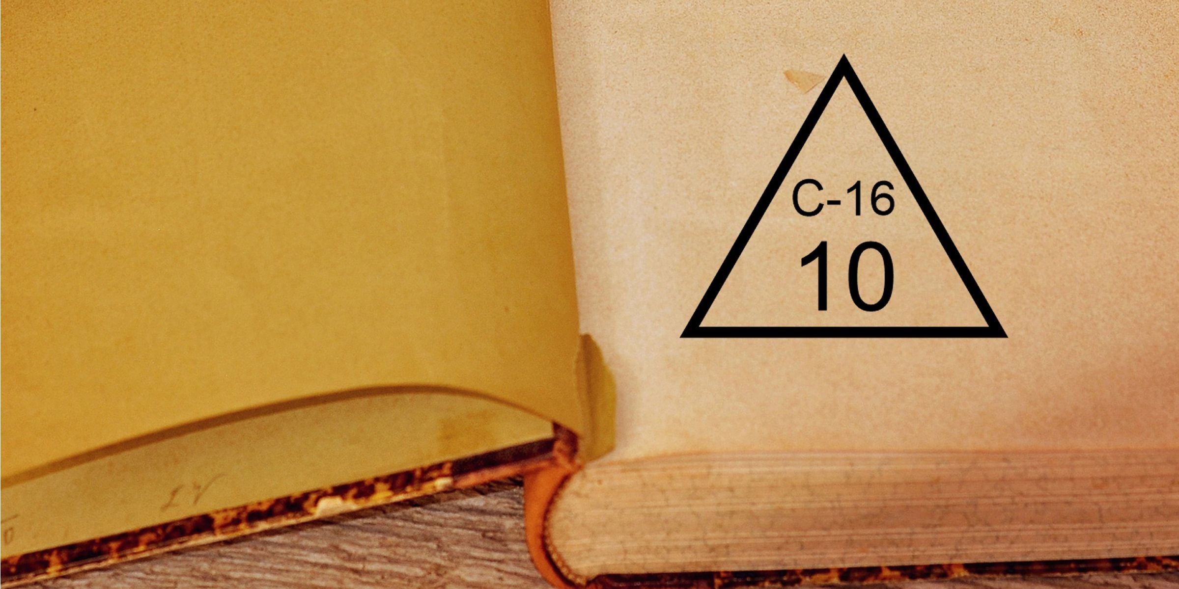 Open book page showing a recycling symbol triangle labeled C-16 with the number 10 printed inside on aged paper
